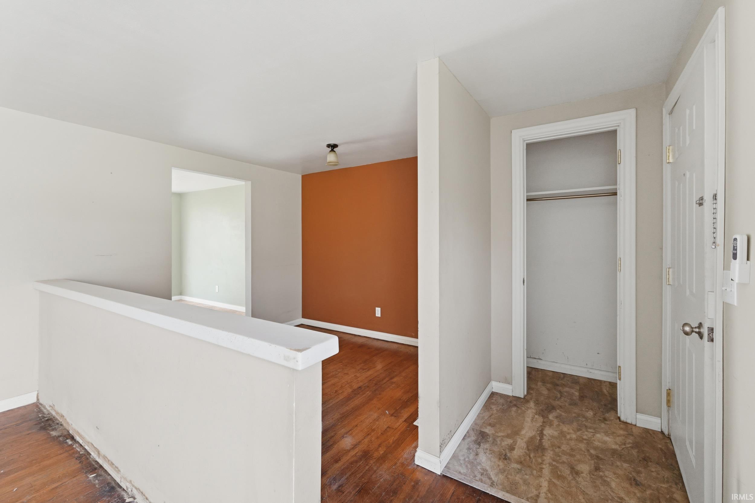 Hallway featuring an upstairs landing and dark wood-style floors