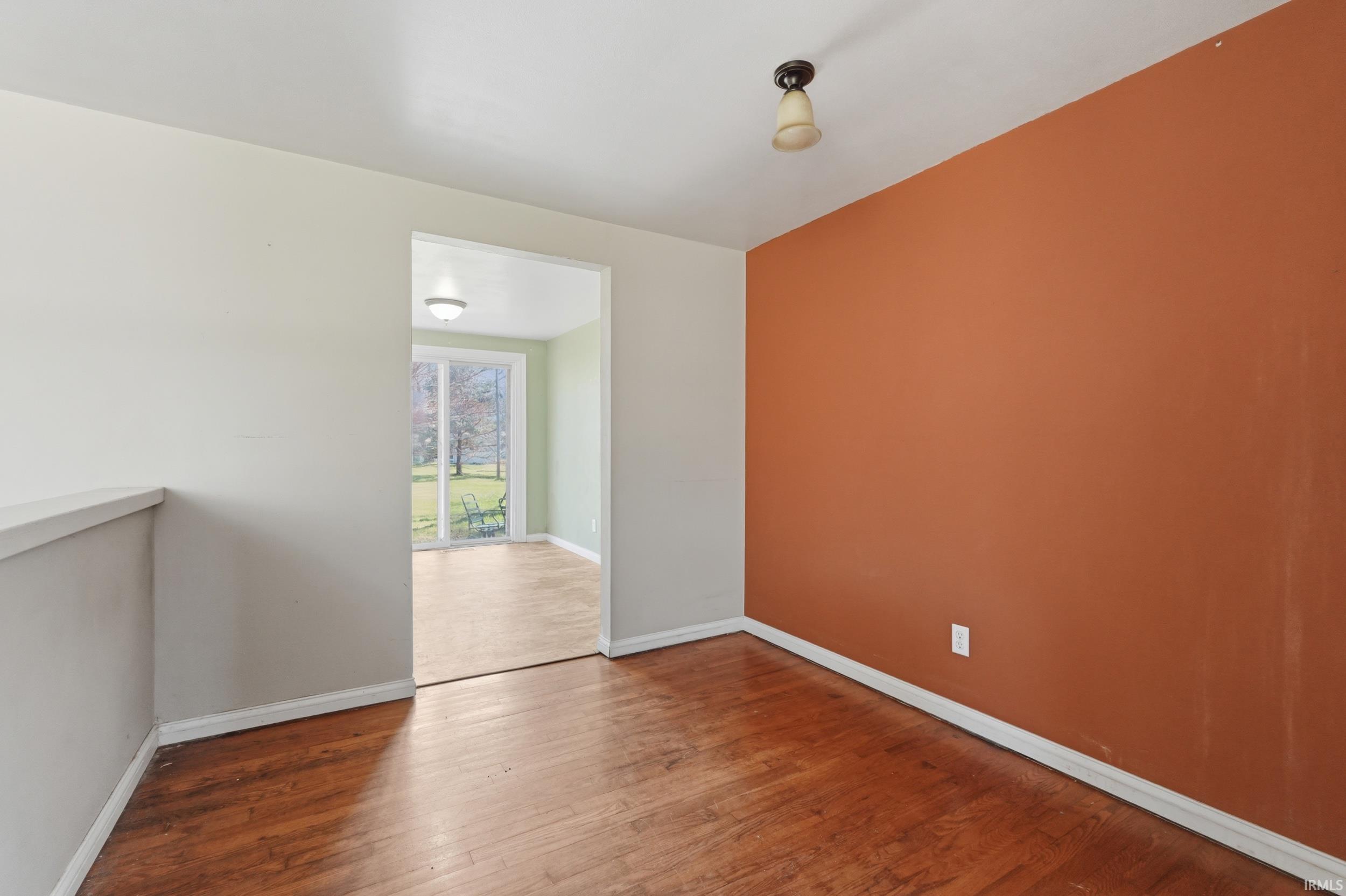 Spare room with hardwood / wood-style floors and baseboards