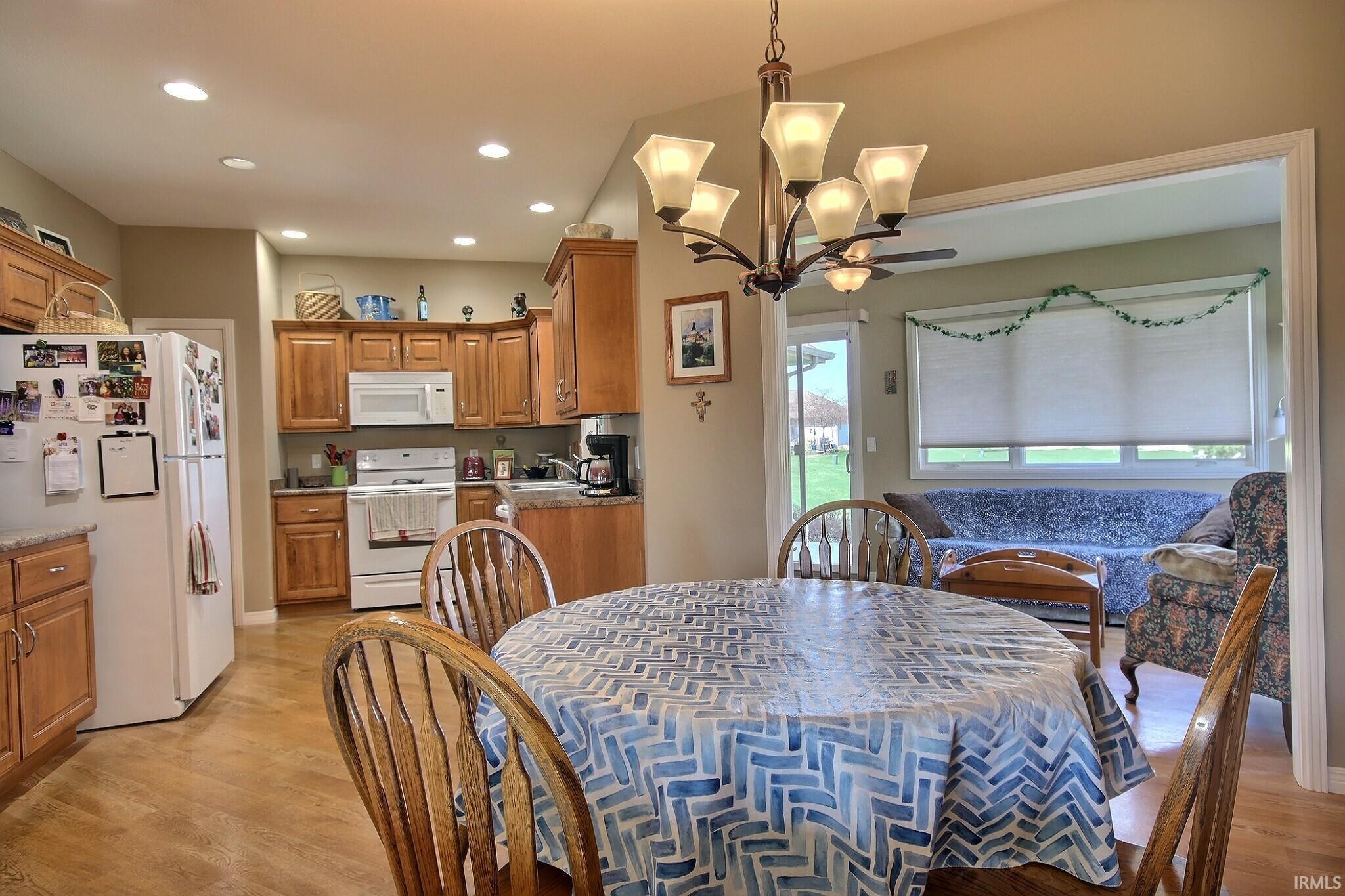 Dining space featuring light wood finished floors, hanging lights, and ceiling fan