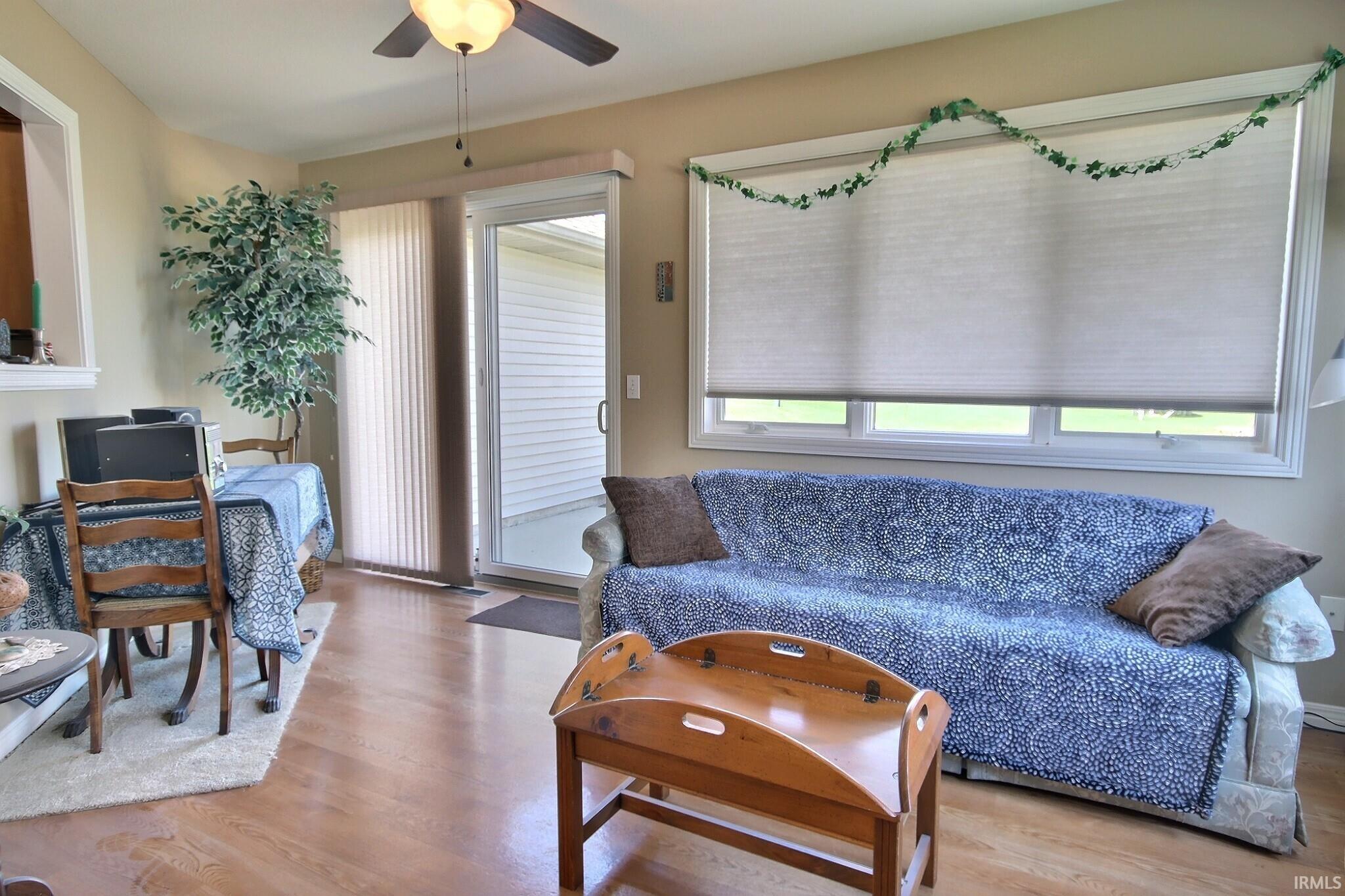 Living area with ceiling fan and light wood-style floors