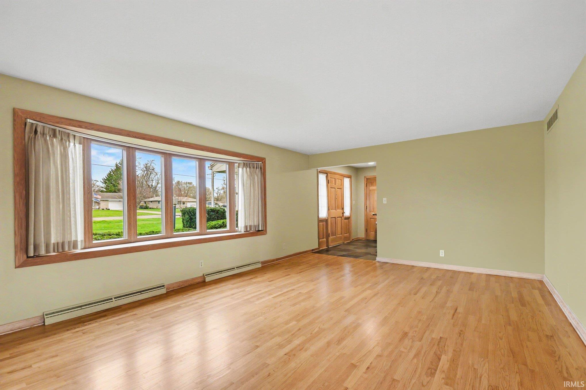 Spare room with a baseboard radiator and light wood-style flooring