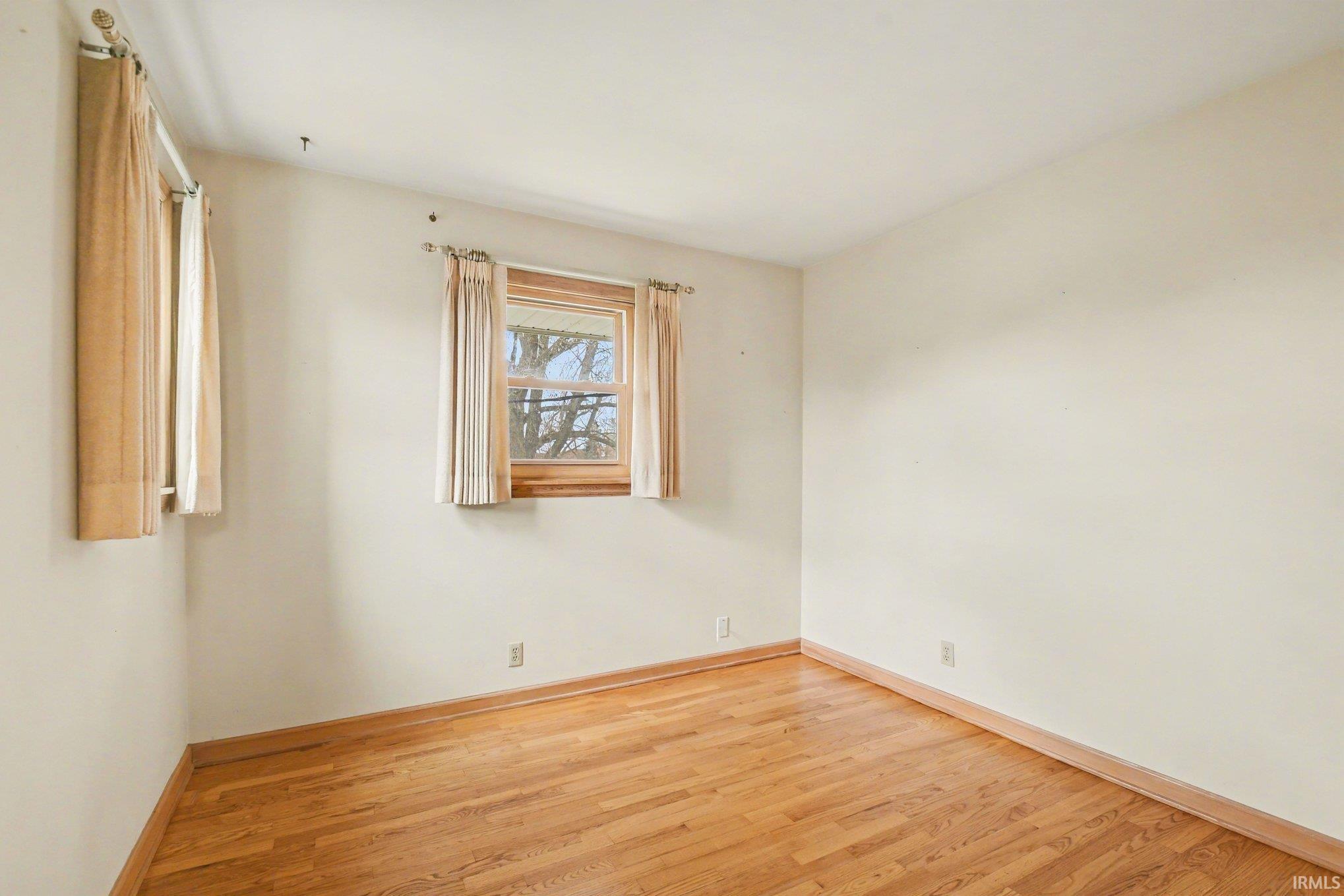 Spare room featuring light wood-style floors and baseboards