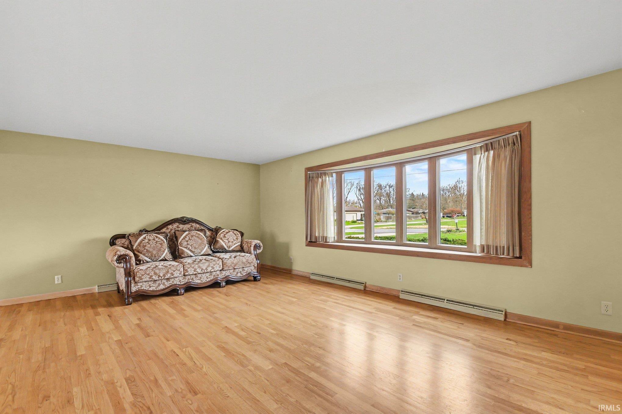 Sitting room featuring light wood finished floors and a baseboard heating unit