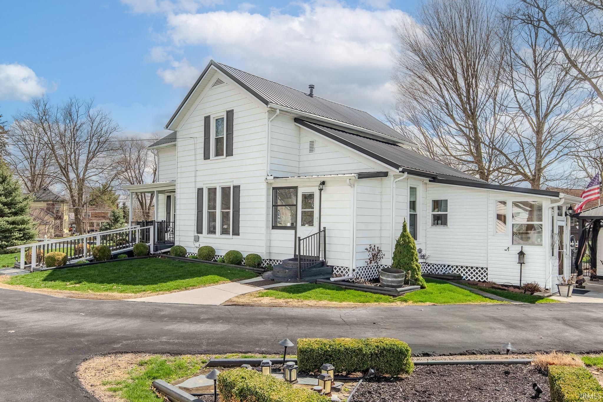 View of front of home with a front lawn and a metal roof