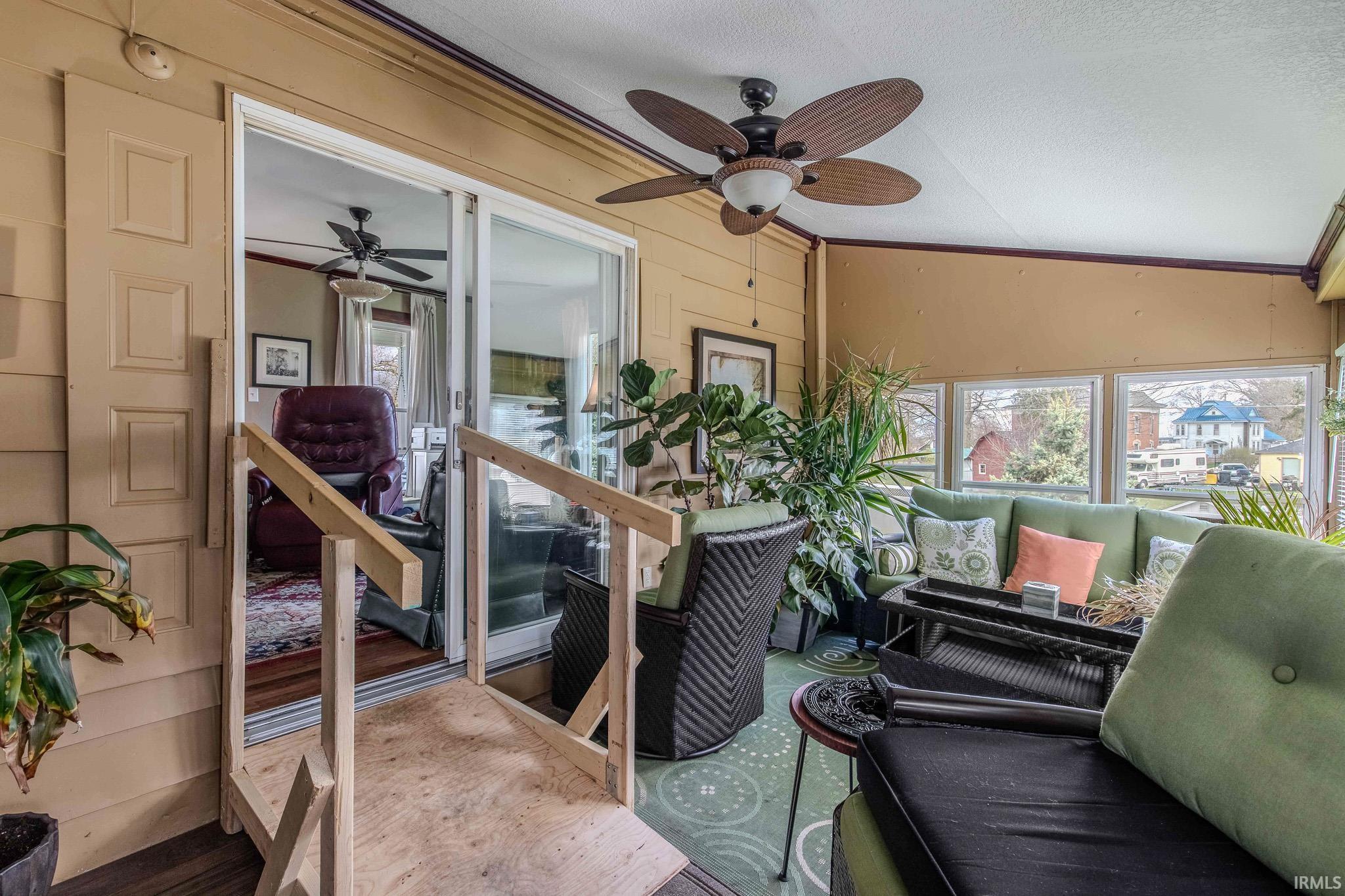 Sunroom with ceiling fan and an outdoor living space