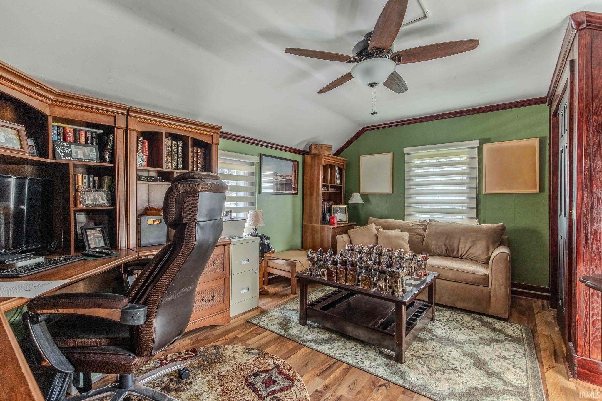 Office area featuring light wood-style flooring, ceiling fan, lofted ceiling, and ornamental molding