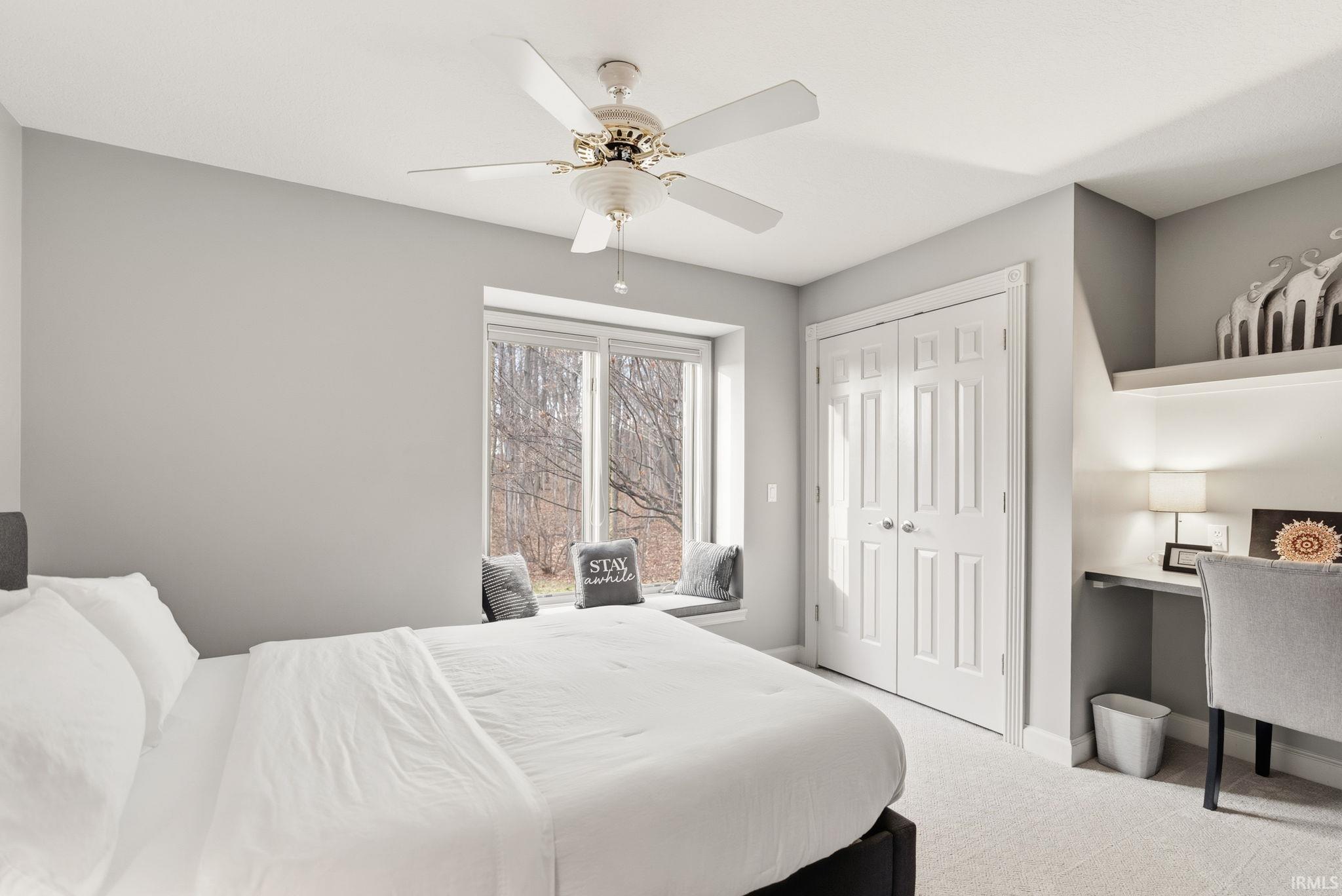 Bedroom featuring light colored carpet, a closet, and ceiling fan