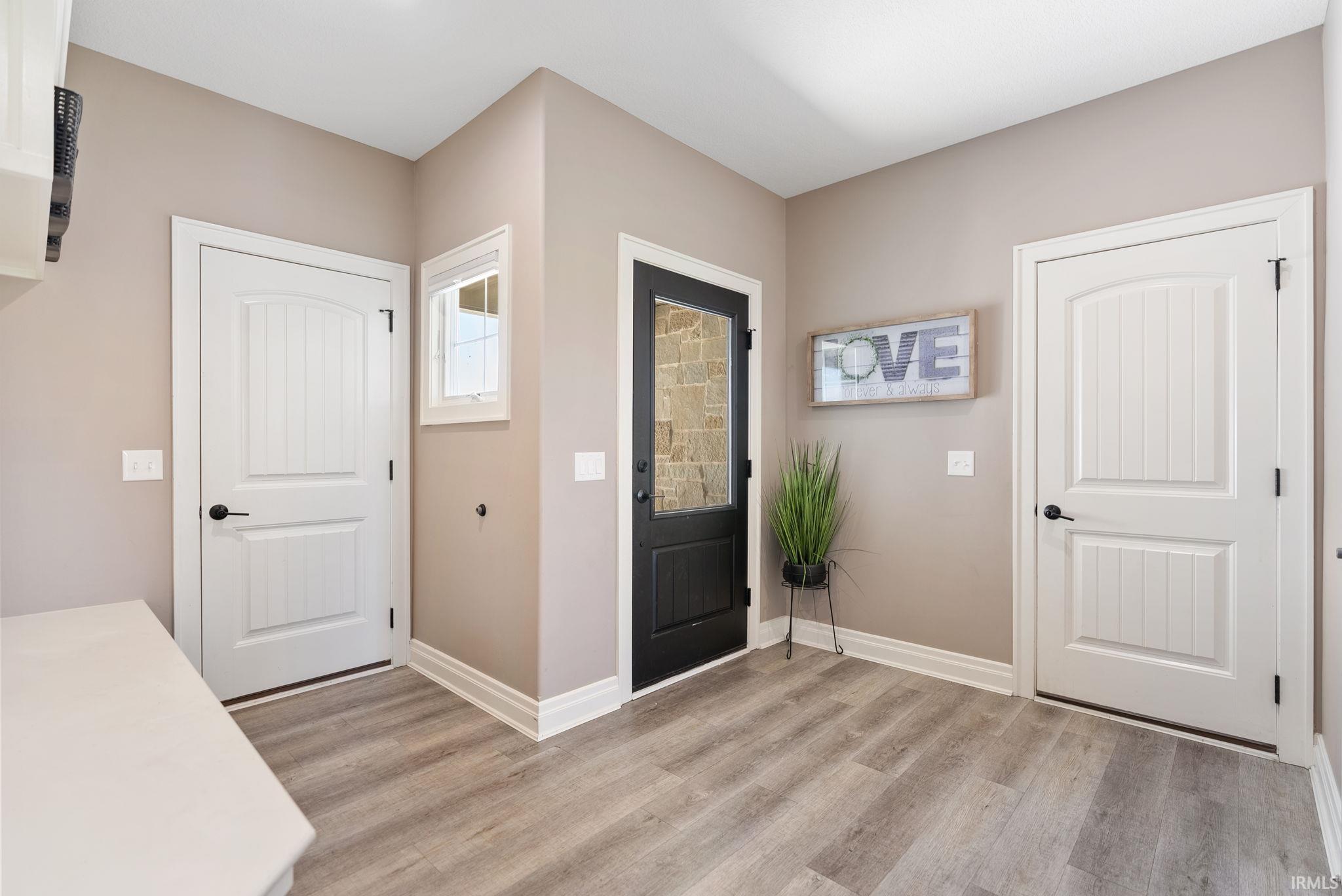 Entrance foyer with baseboards and light wood-style floors