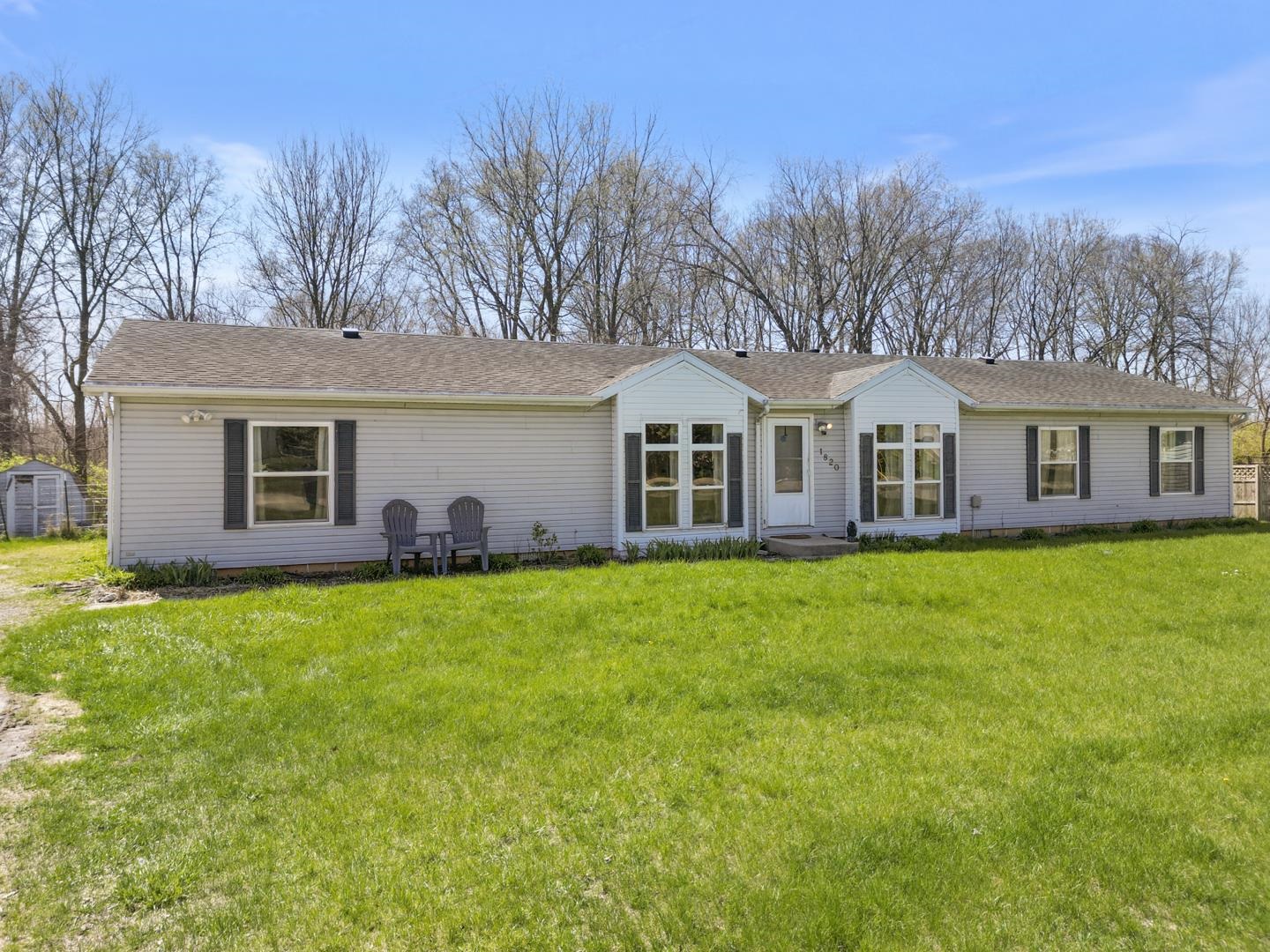Ranch-style house featuring a front lawn and roof with shingles