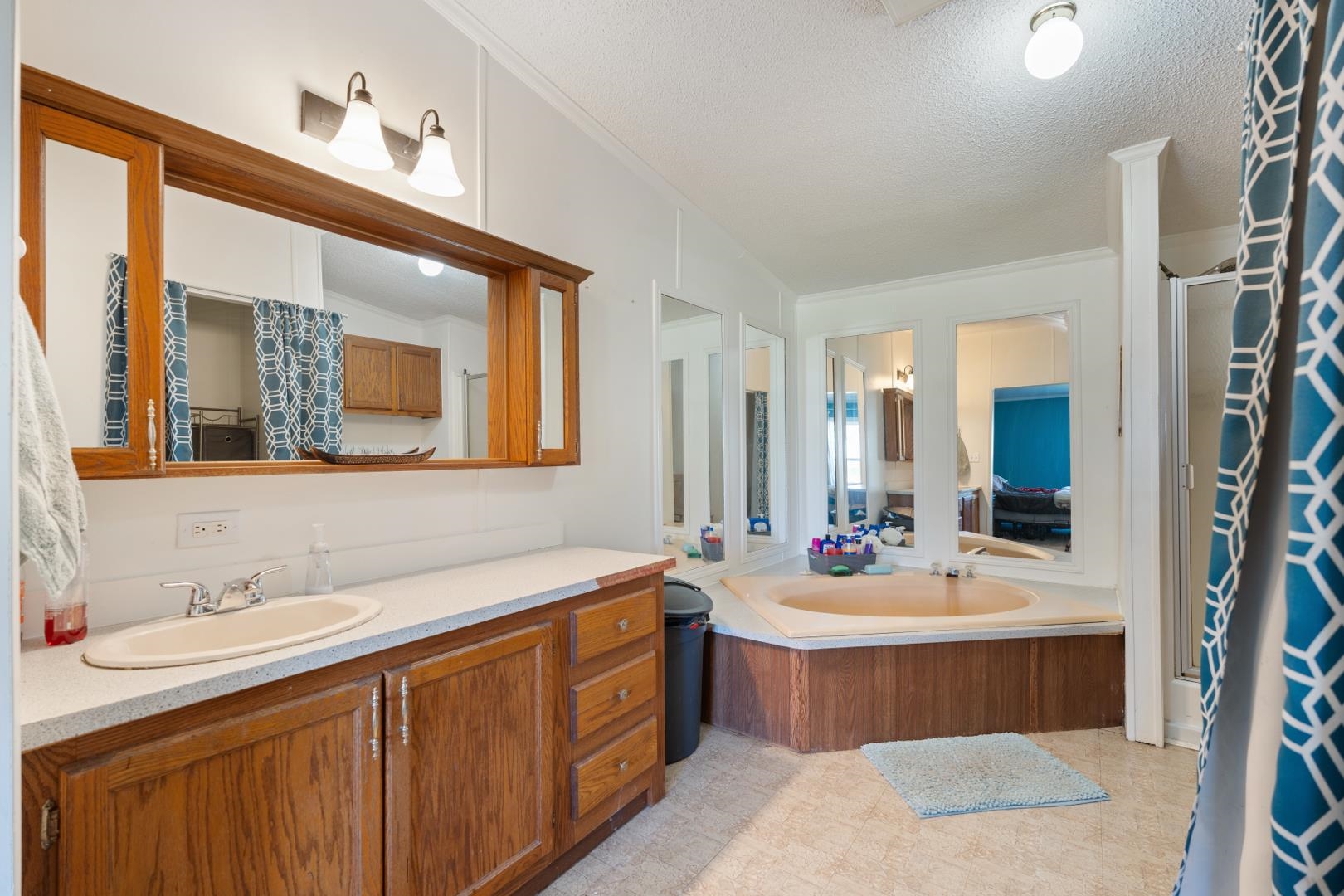 Ensuite bathroom with a textured ceiling, vanity, a shower stall, and a bath