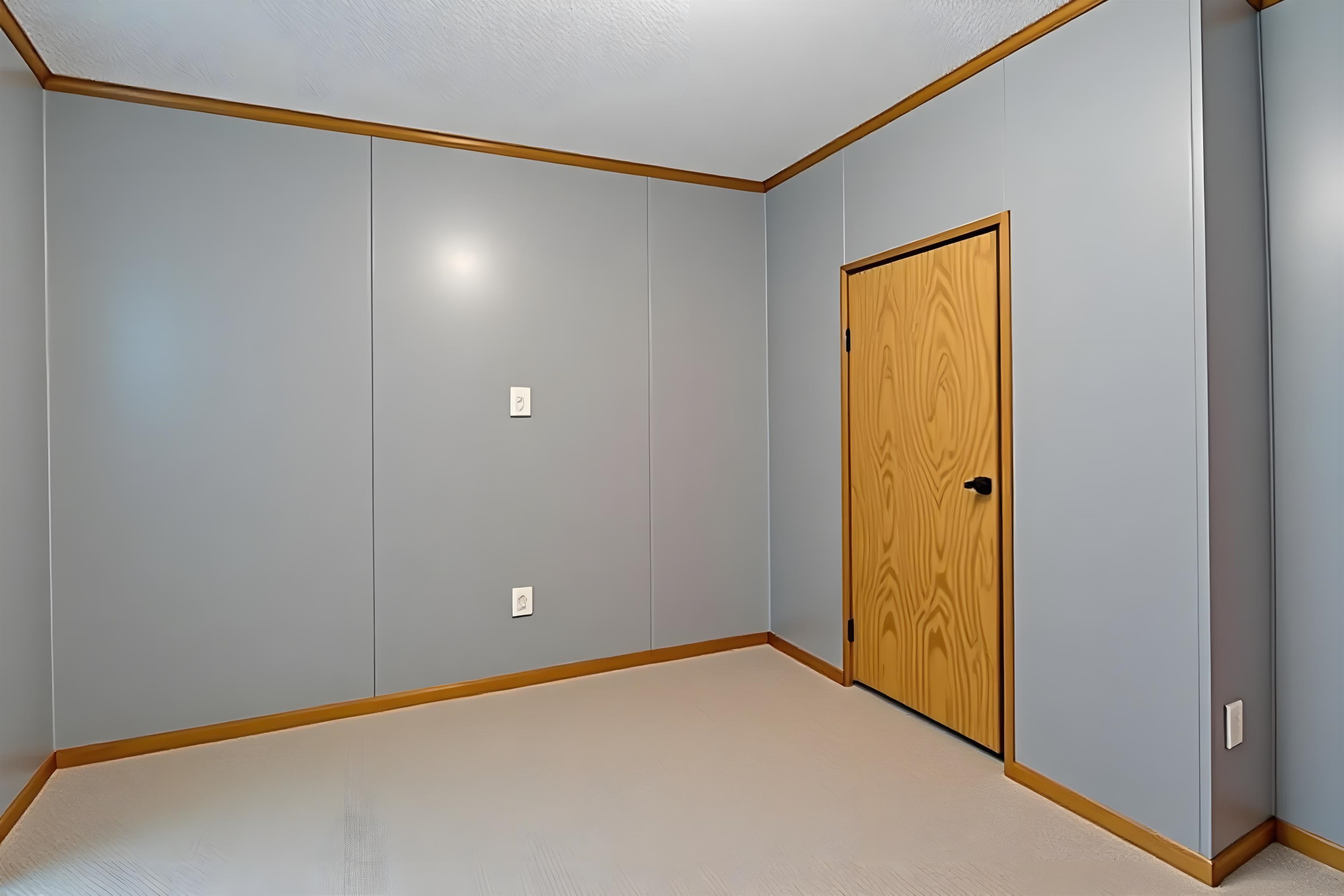 Unfurnished room with a decorative wall, light carpet, and crown molding