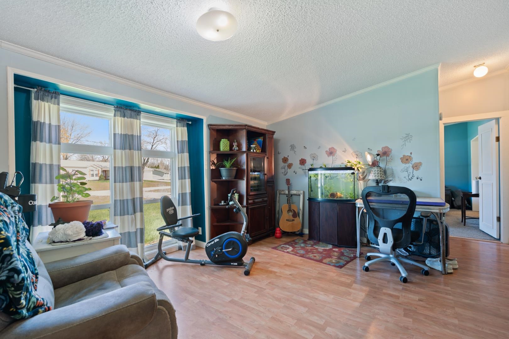 Office area with wood finished floors, crown molding, and a textured ceiling