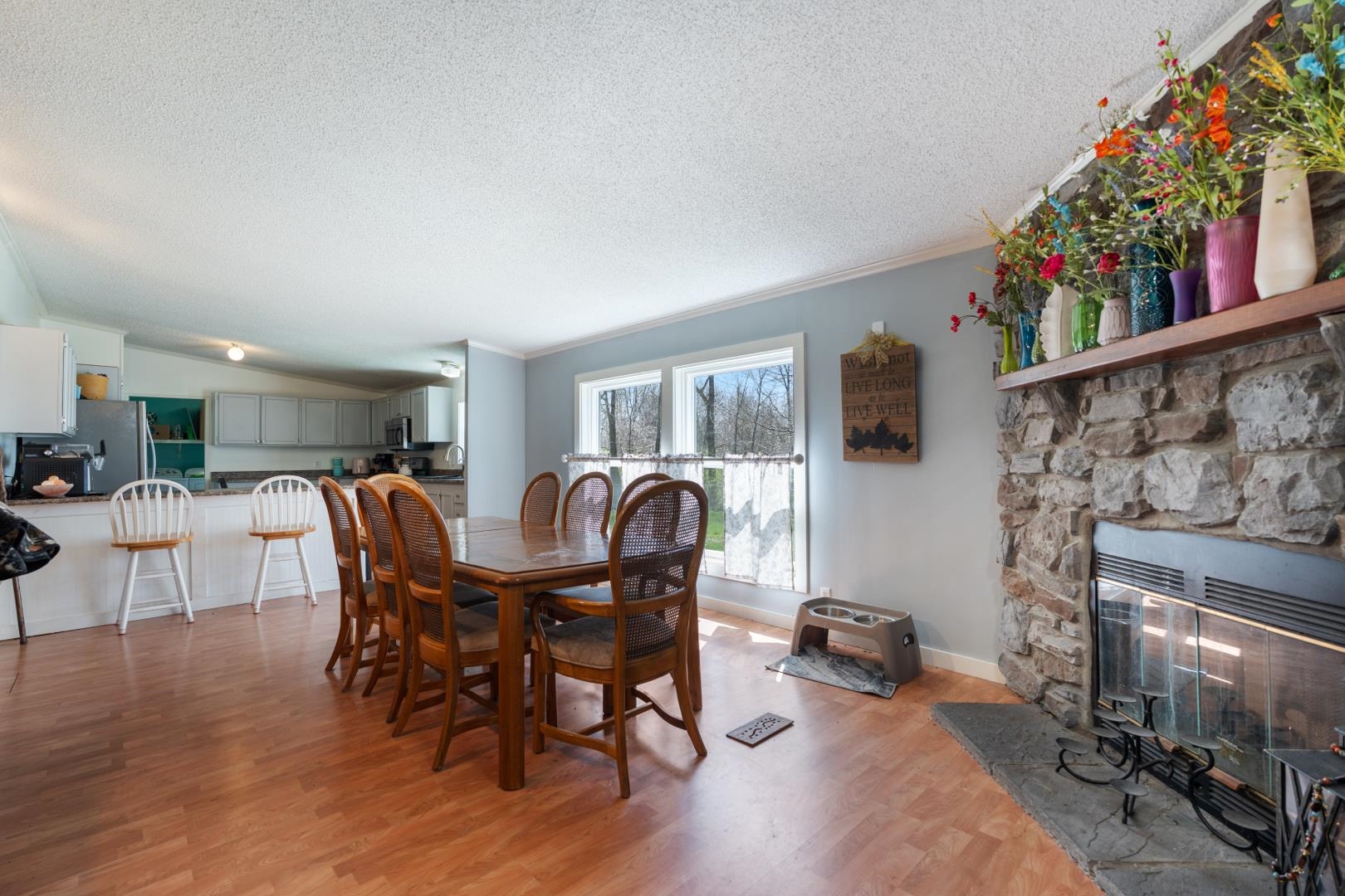 Dining room featuring crown molding, light wood finished floors, and a fireplace