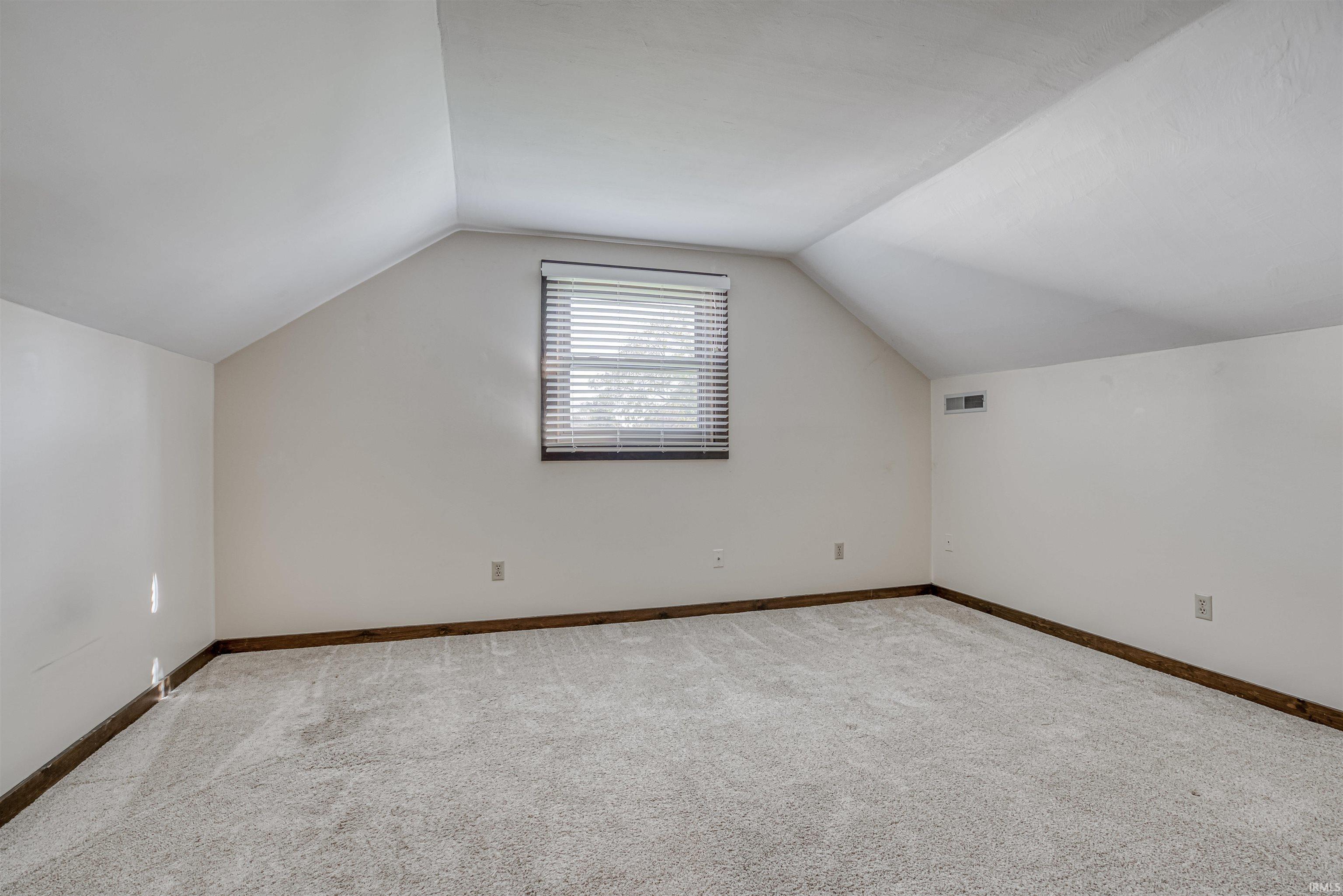 Additional living space featuring carpet flooring and baseboards