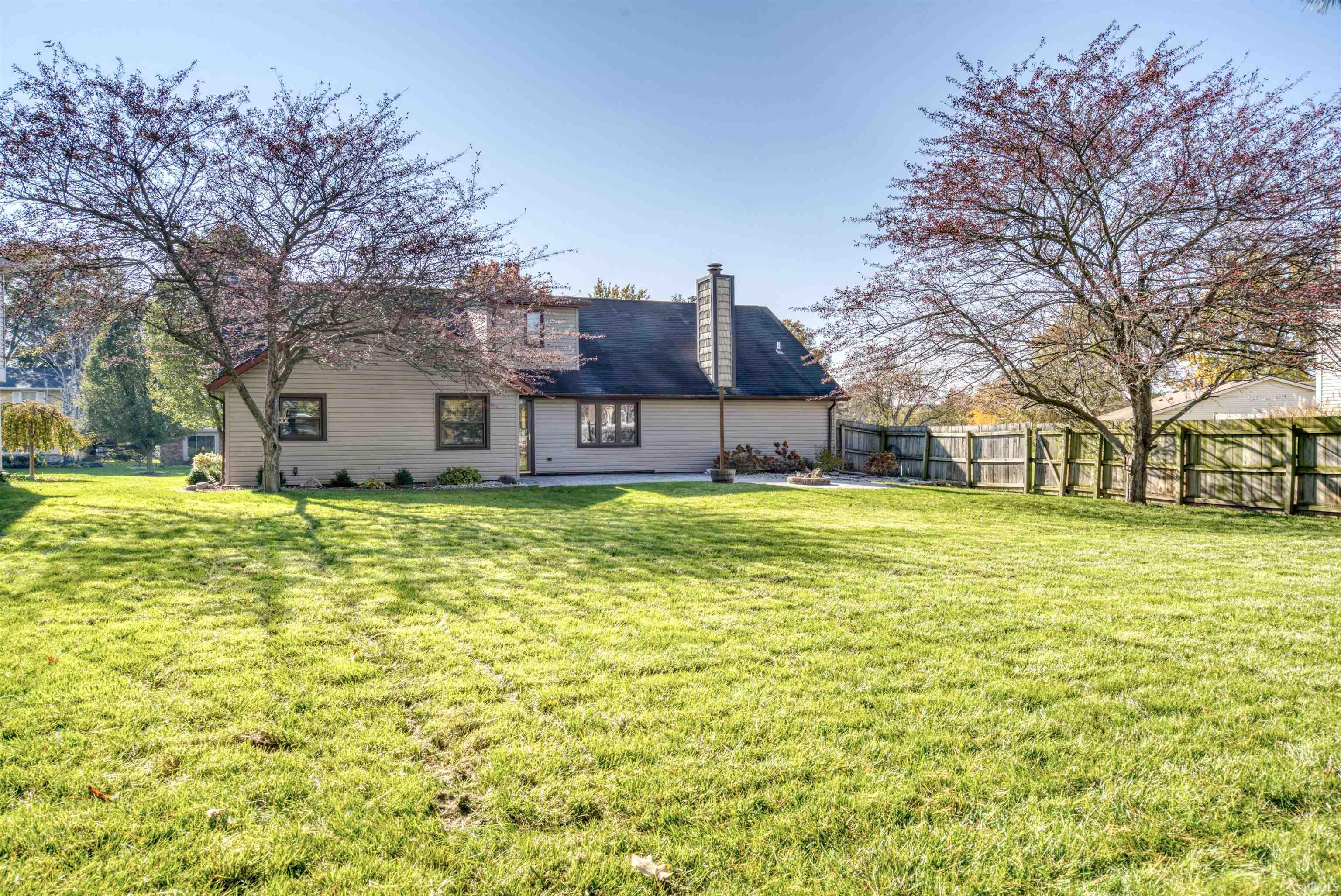 Back of property featuring a chimney, a fenced backyard, and a patio