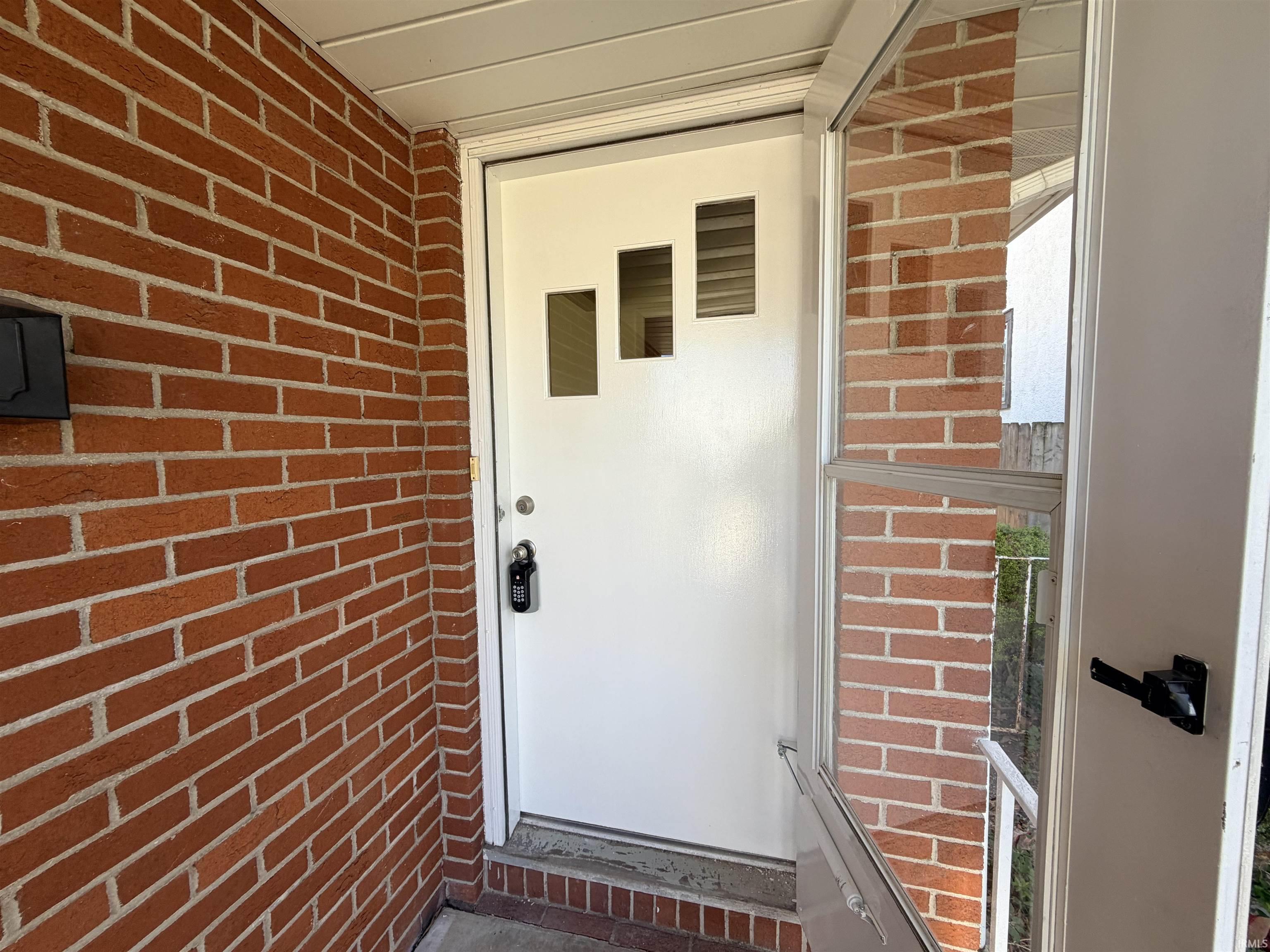 View of exterior entry featuring brick siding