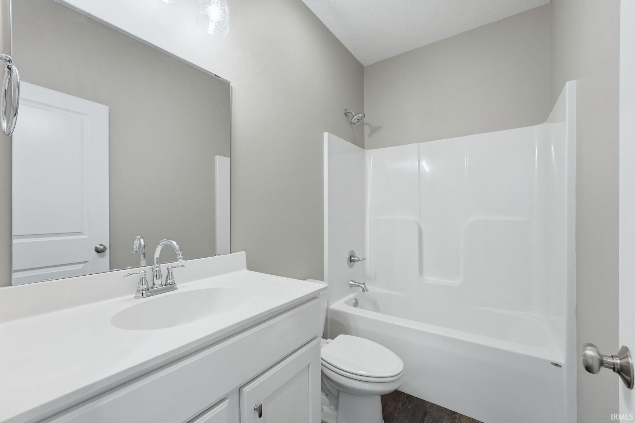 Full bathroom featuring vanity, shower / washtub combination, and dark wood finished floors