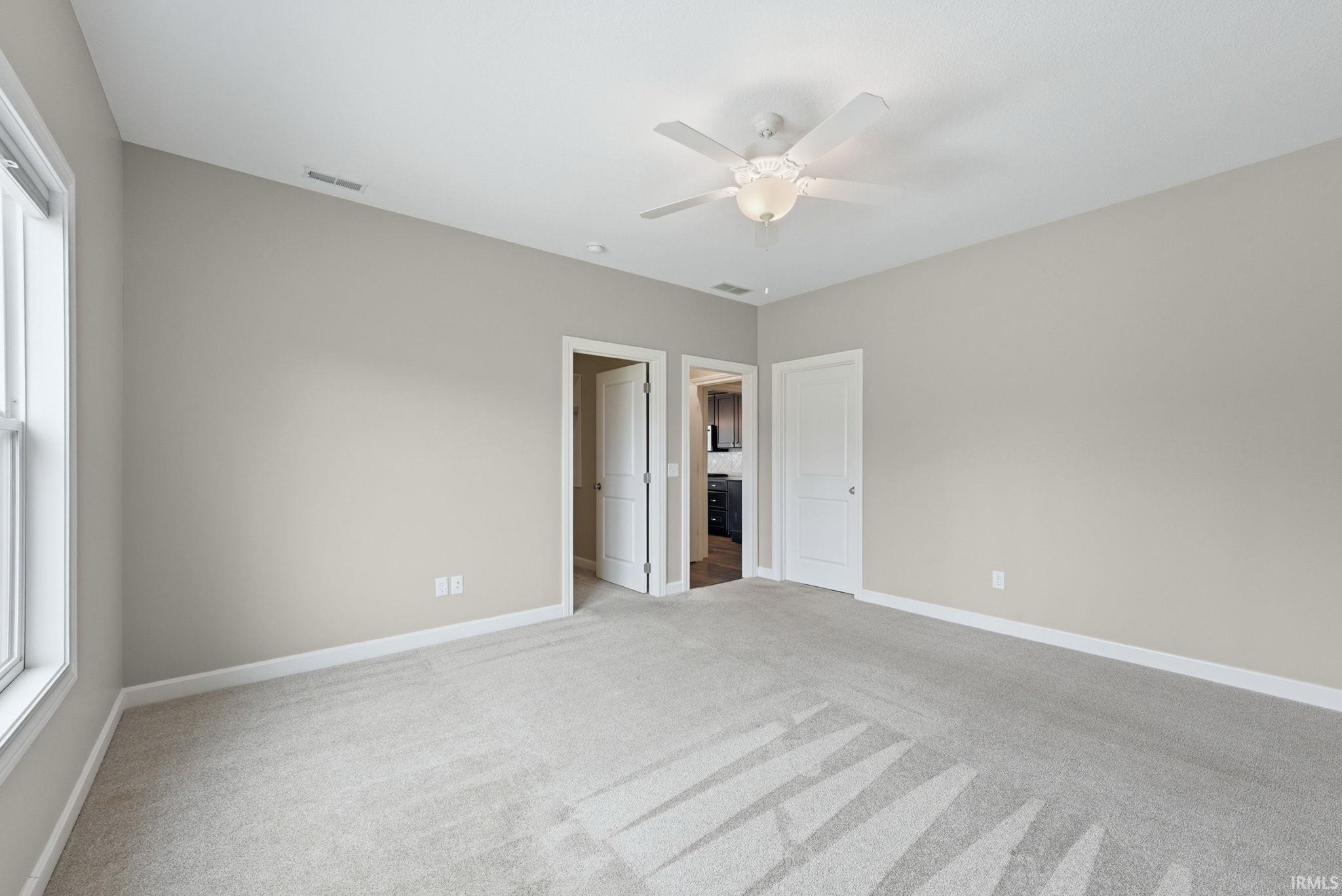 Unfurnished bedroom featuring light carpet, a ceiling fan, and a closet