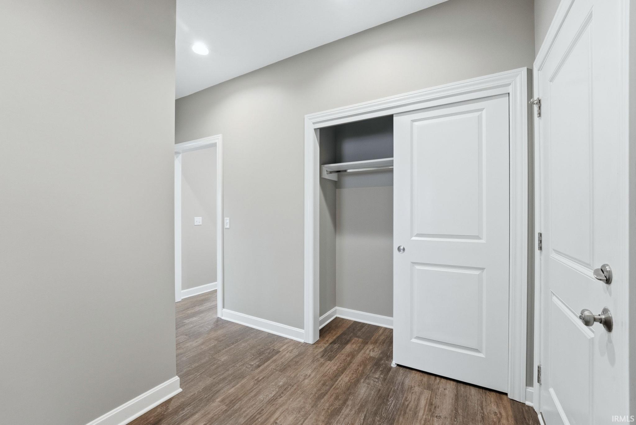 Unfurnished bedroom featuring dark wood finished floors, a closet, and recessed lighting