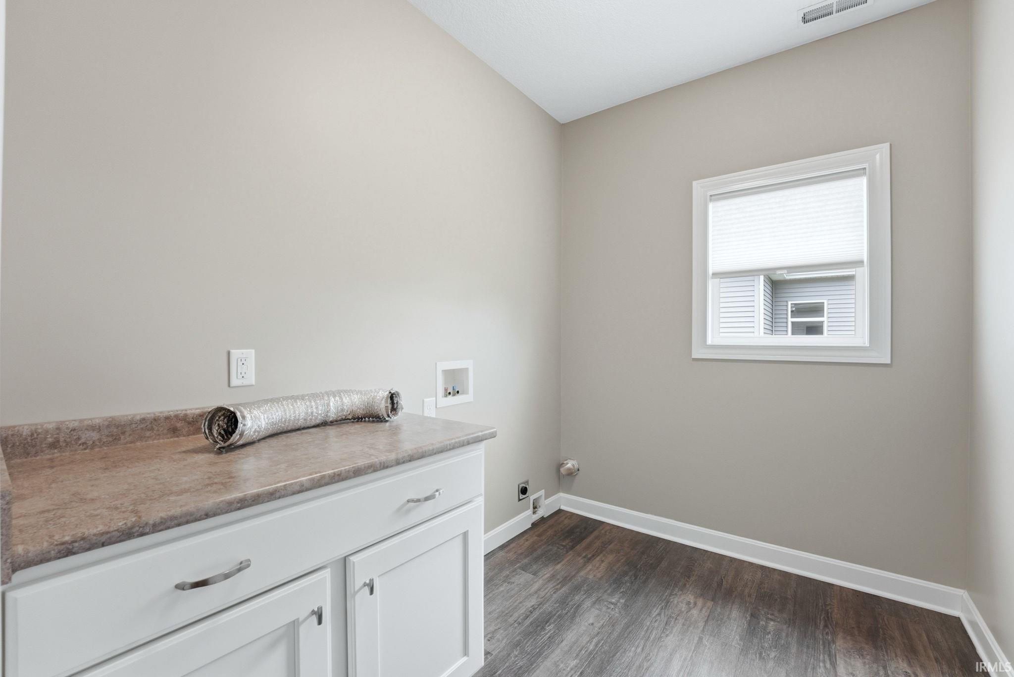 Laundry room with dark wood-style flooring, washer hookup, and electric dryer hookup