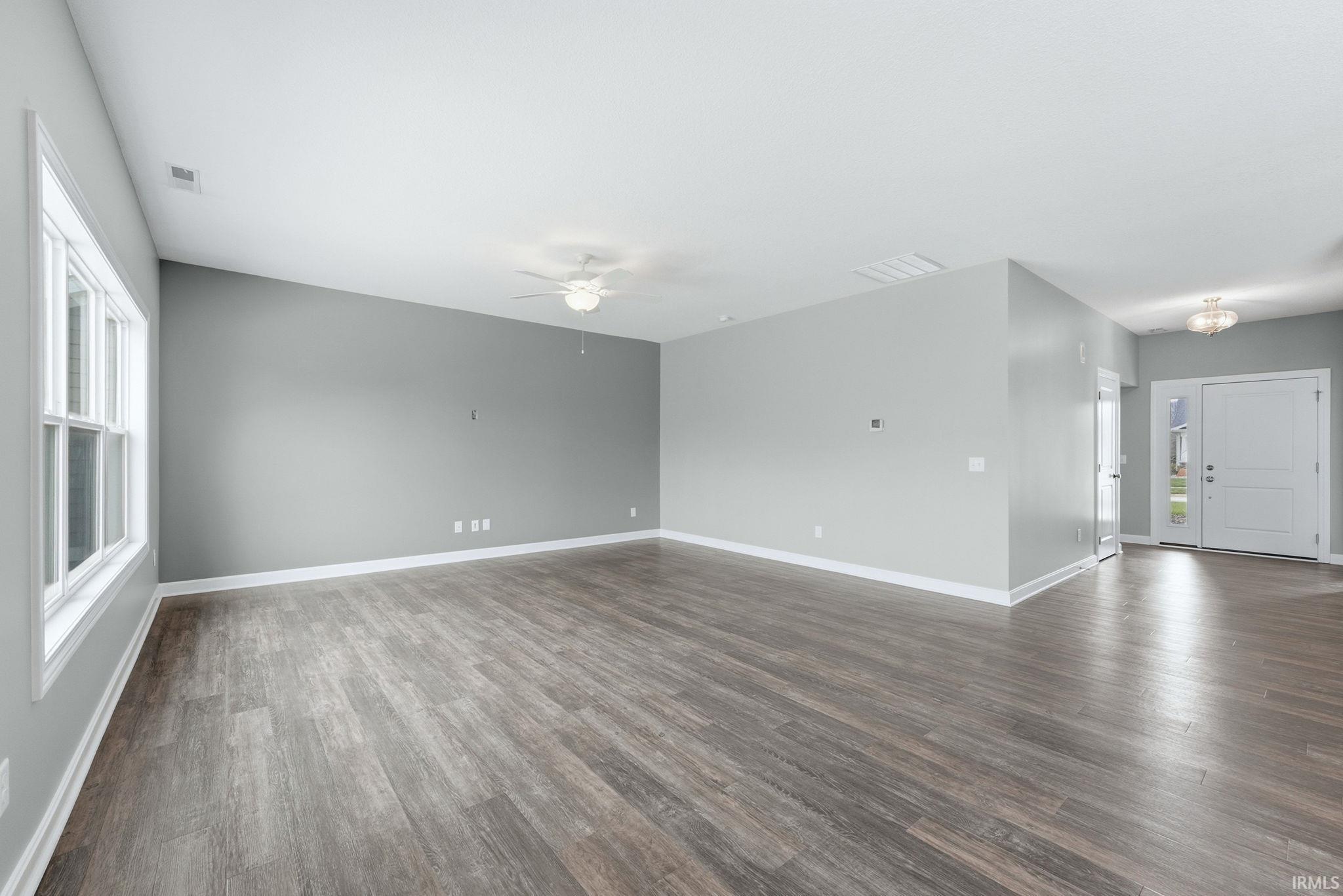 Unfurnished room featuring dark wood finished floors and ceiling fan