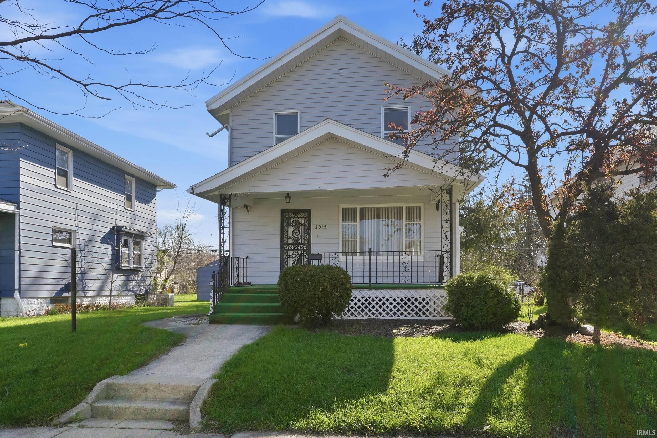 View of front of property with a porch and a front lawn