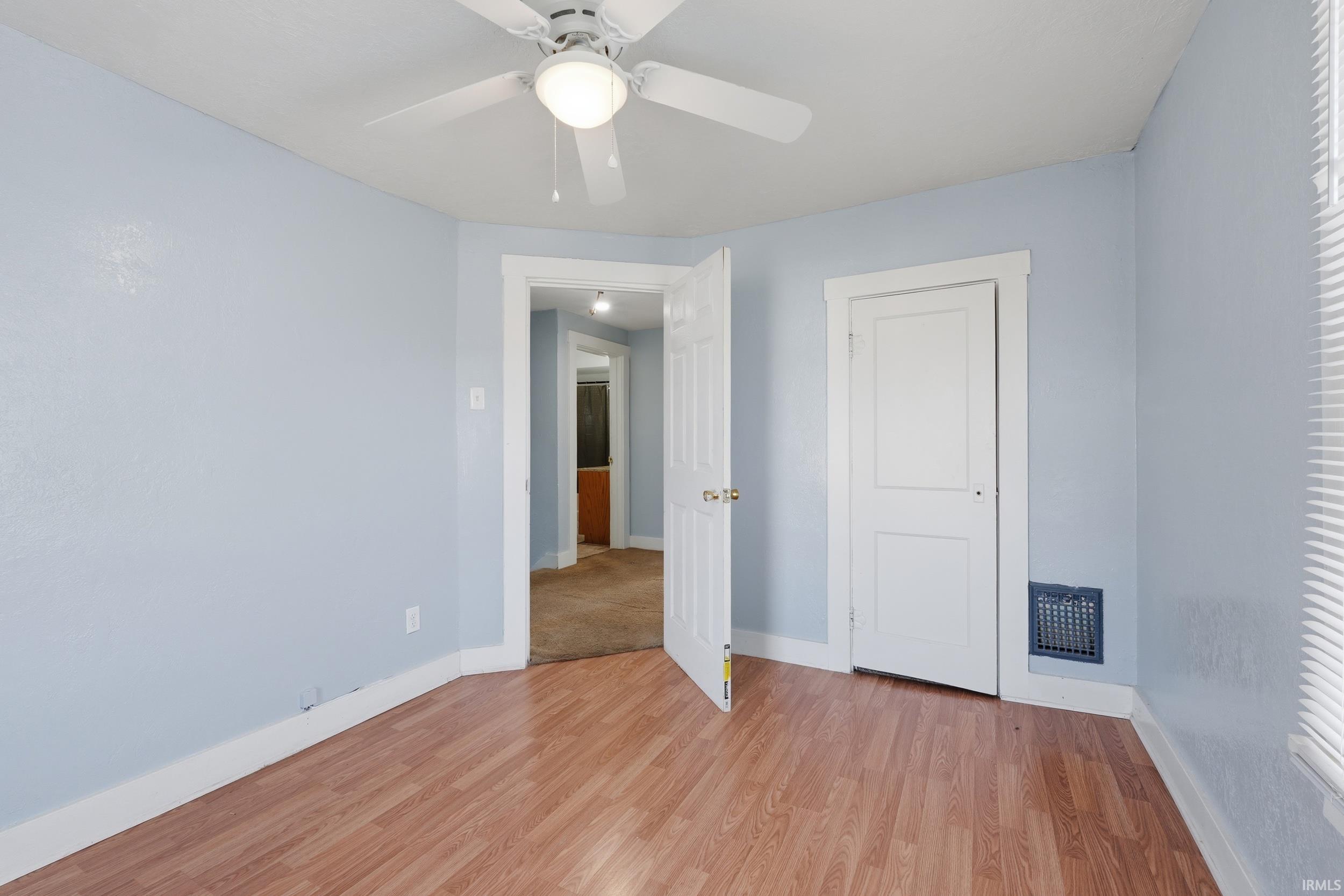 Unfurnished room featuring light wood-style floors and a ceiling fan