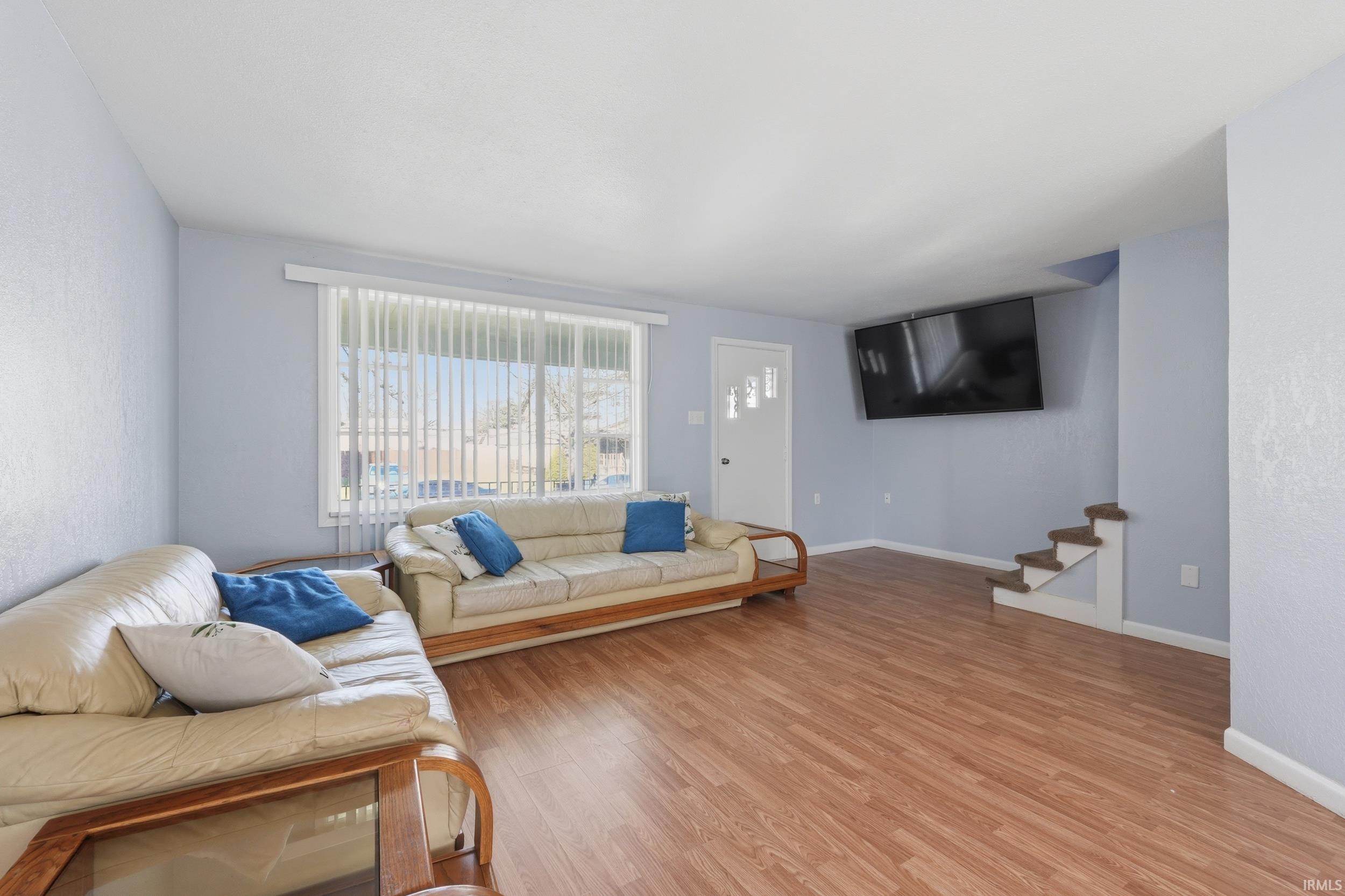 Living area featuring light wood-type flooring and a textured wall