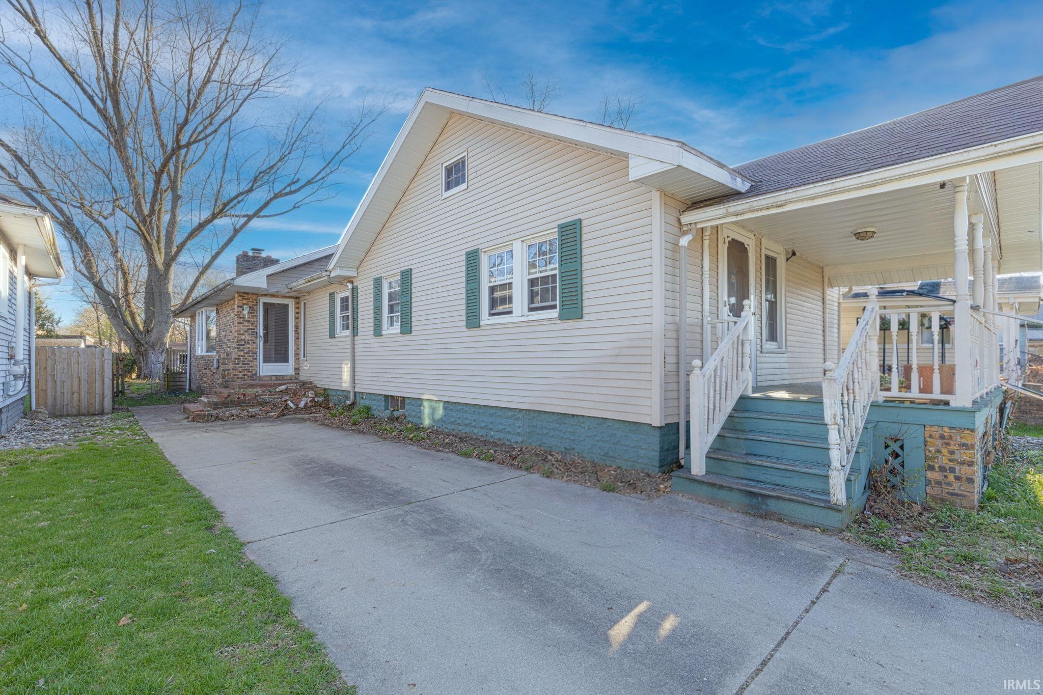 Bungalow-style home with a shingled roof, a patio, and a porch