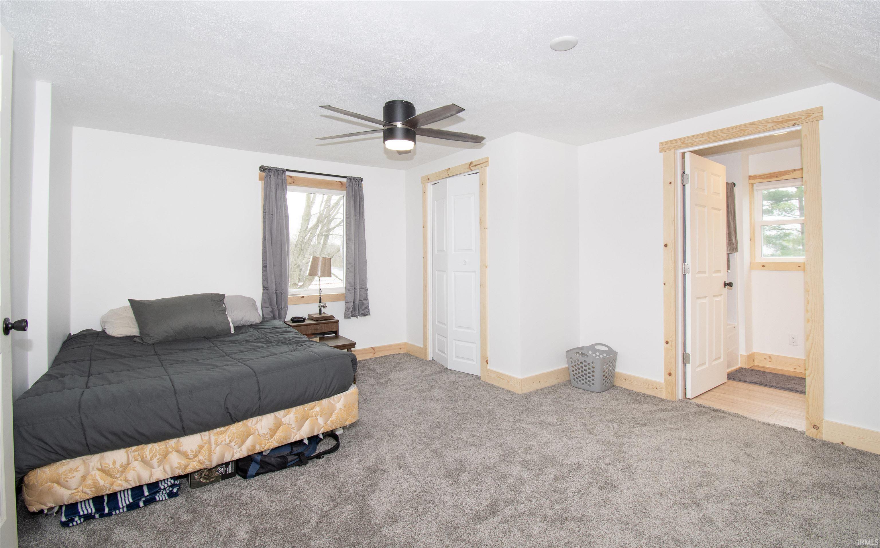 Bedroom featuring light carpet, ceiling fan, and a closet