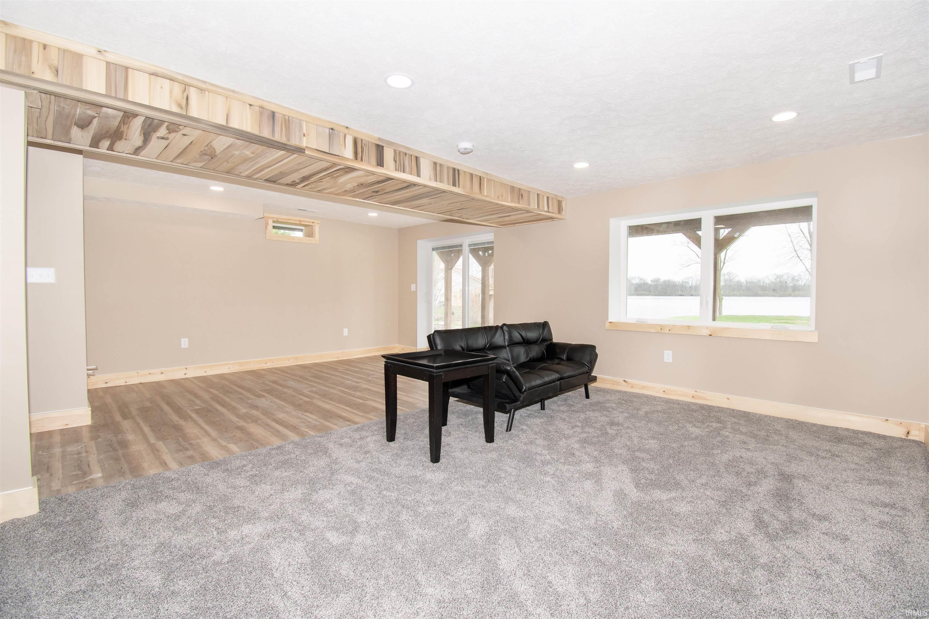 Living area featuring light colored carpet and baseboards
