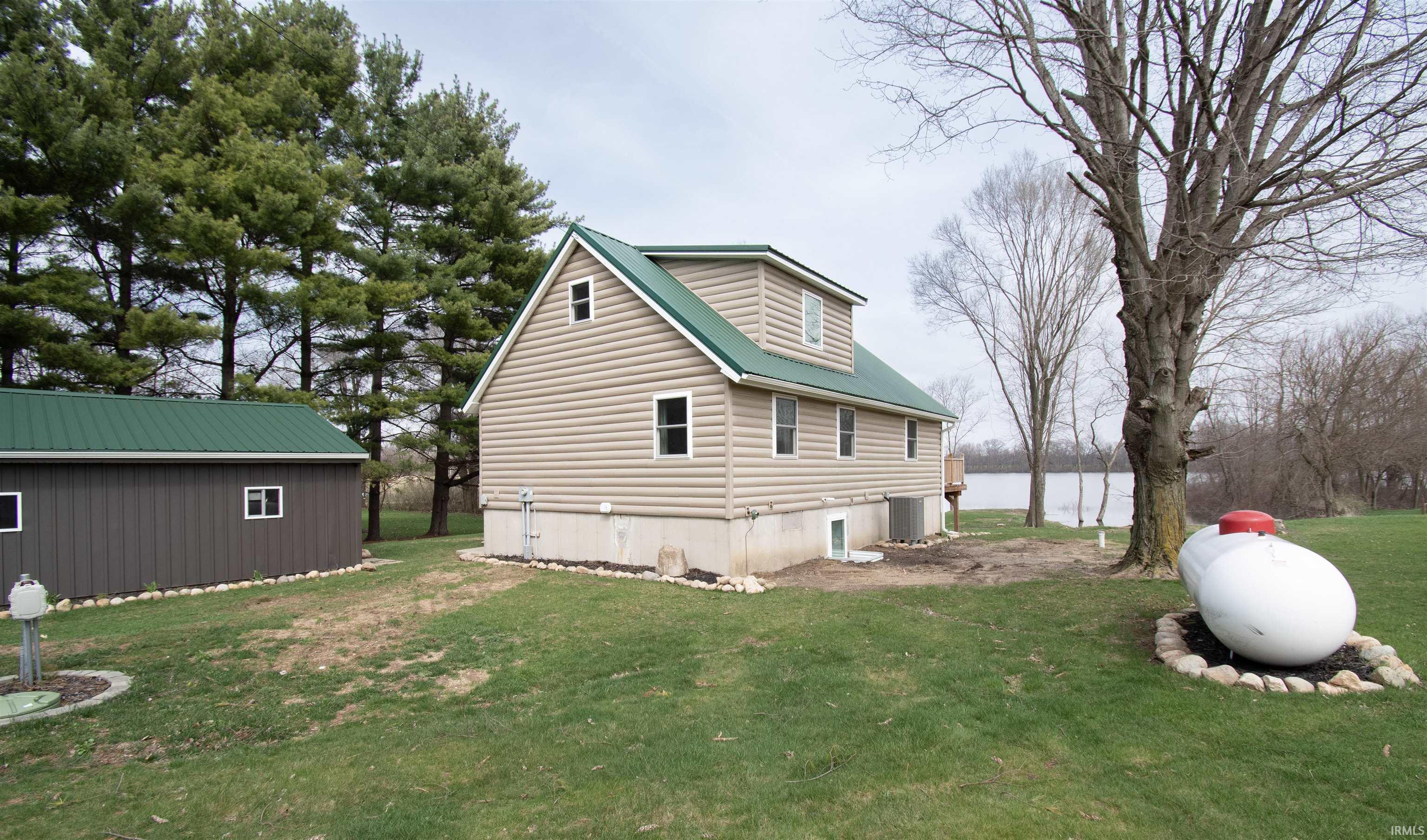 View of property exterior featuring a yard and a water view