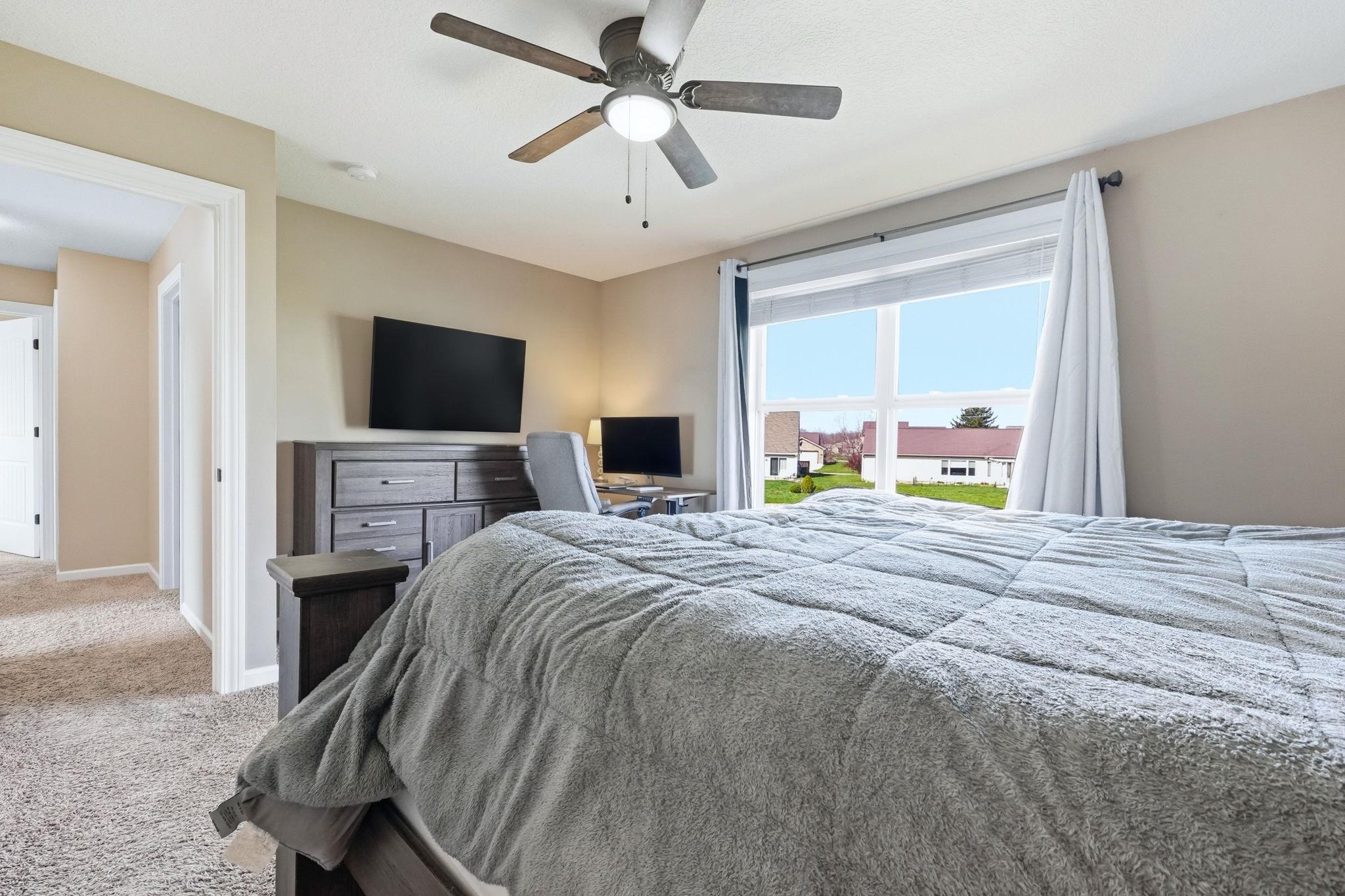 Bedroom featuring light carpet and a ceiling fan