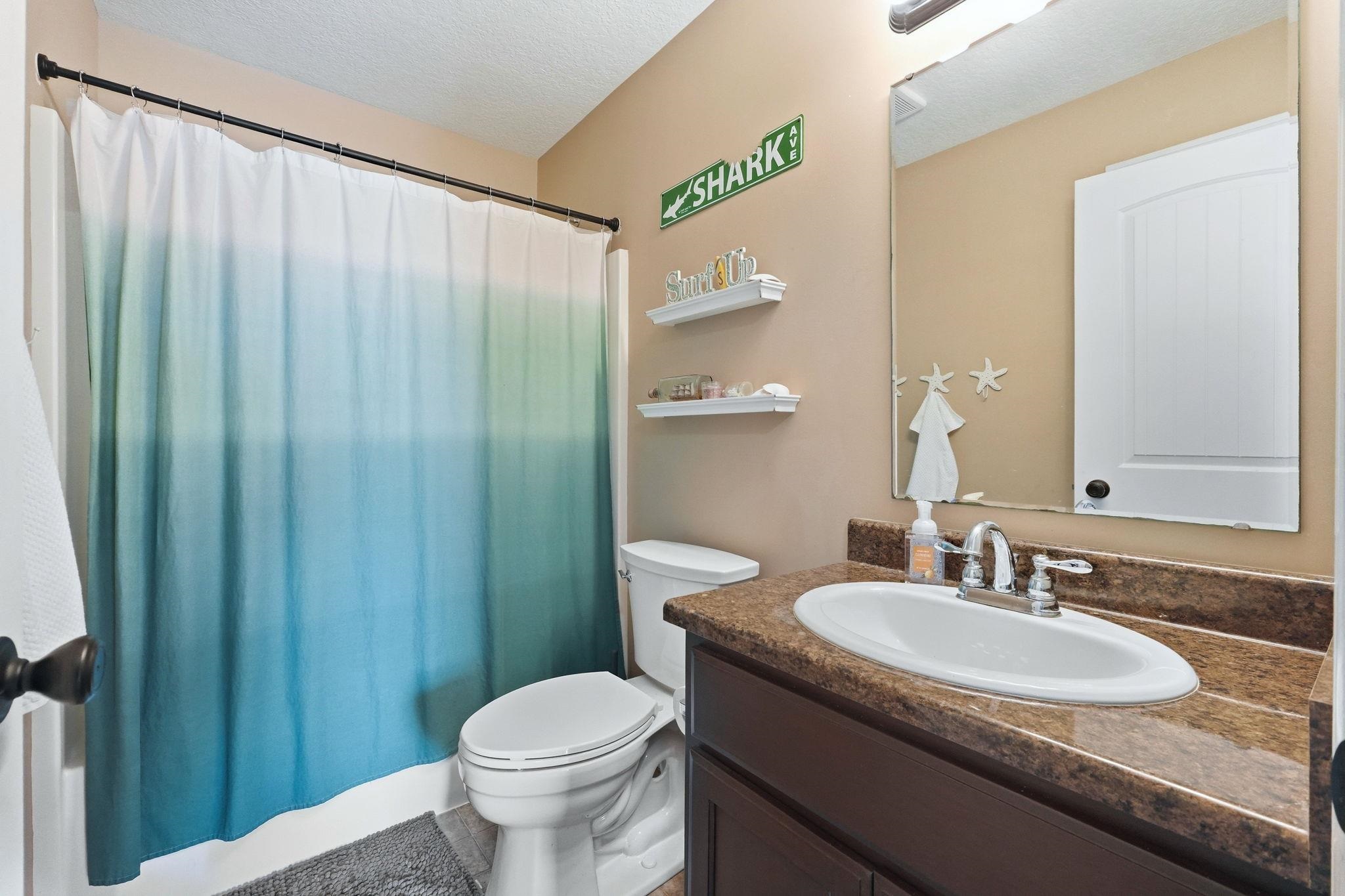 Bathroom with vanity, a textured ceiling, and shower / tub combo with curtain