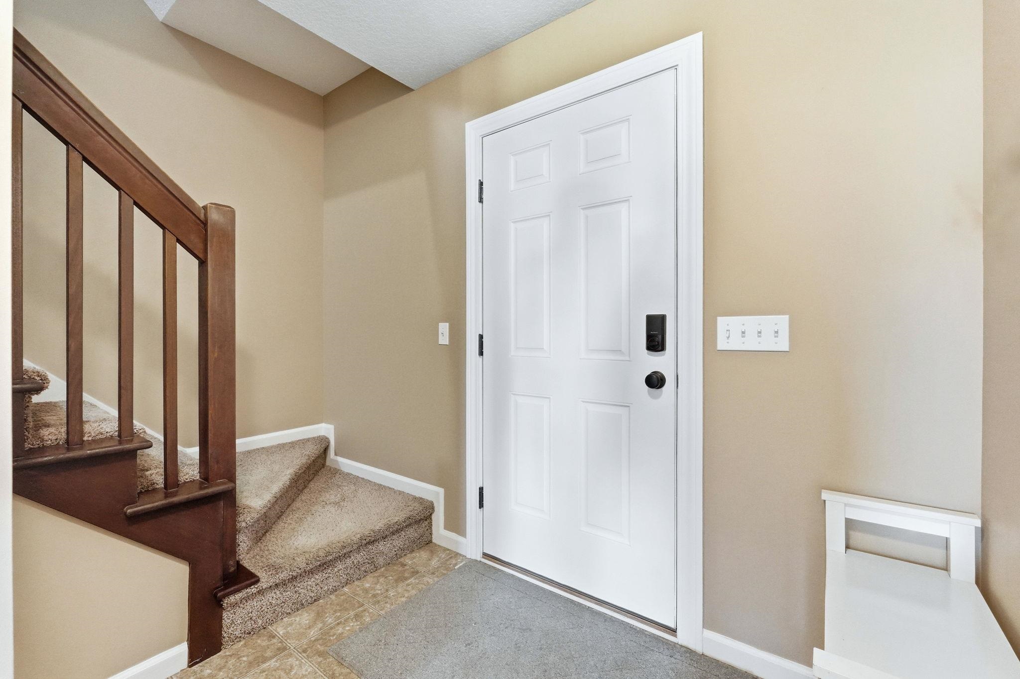 Foyer entrance with stairs and baseboards