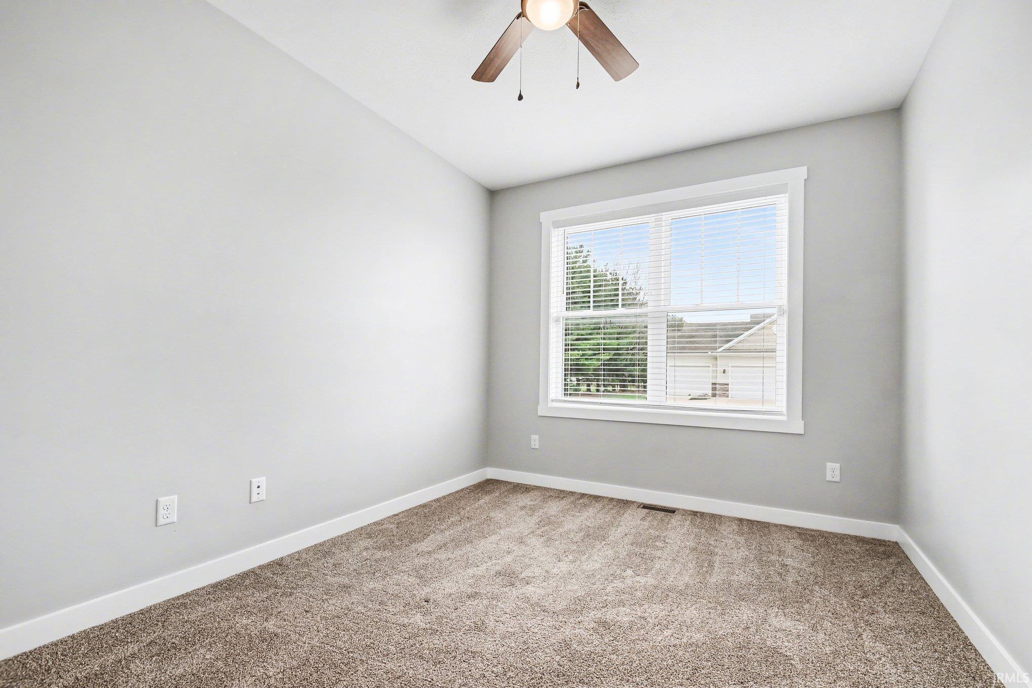 Spare room with a ceiling fan and carpet flooring