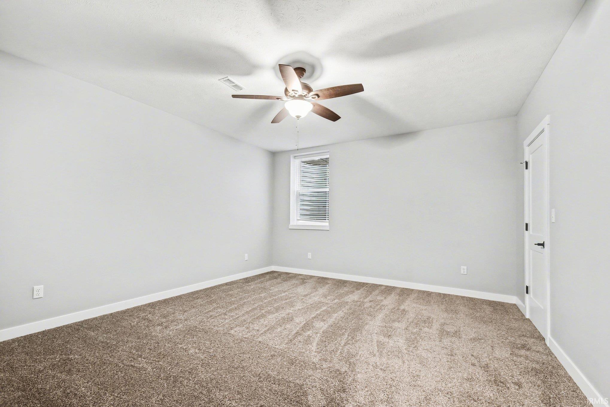 Empty room featuring light carpet and ceiling fan