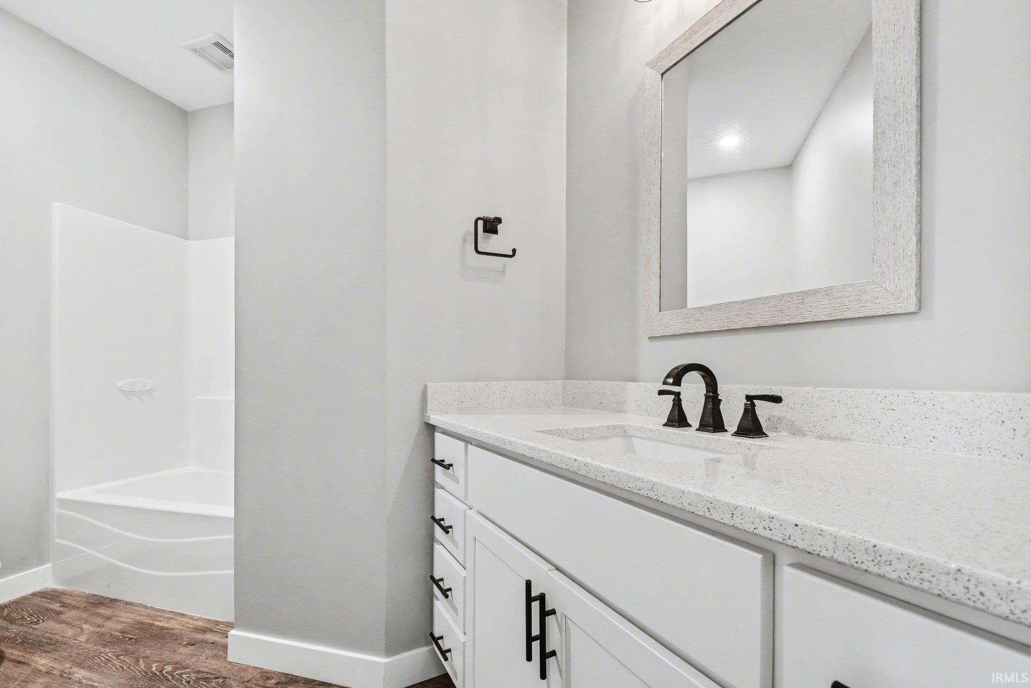 Full bath featuring vanity, dark wood-style flooring, and  shower combination