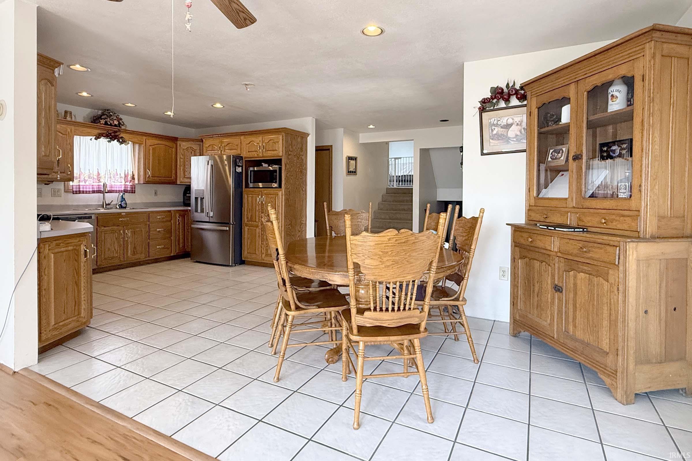 Dining space featuring a ceiling fan, light tile patterned flooring, and recessed lighting