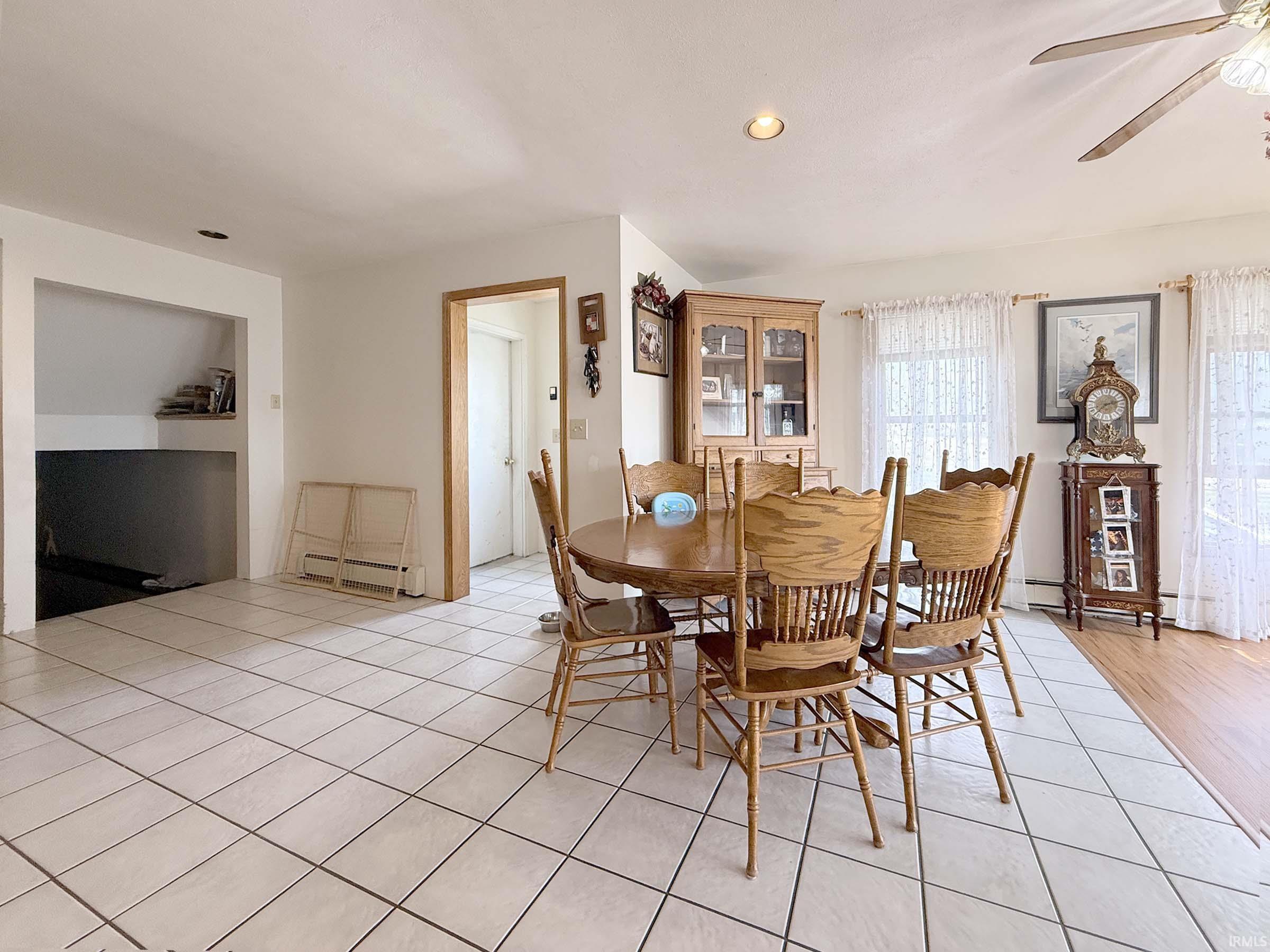 Dining area with a ceiling fan, baseboard heating, recessed lighting, and light tile patterned floors