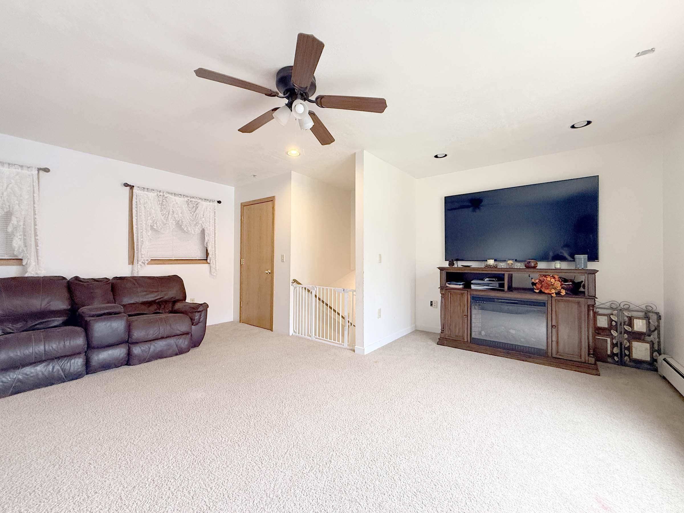 Living room featuring light carpet, a ceiling fan, and recessed lighting
