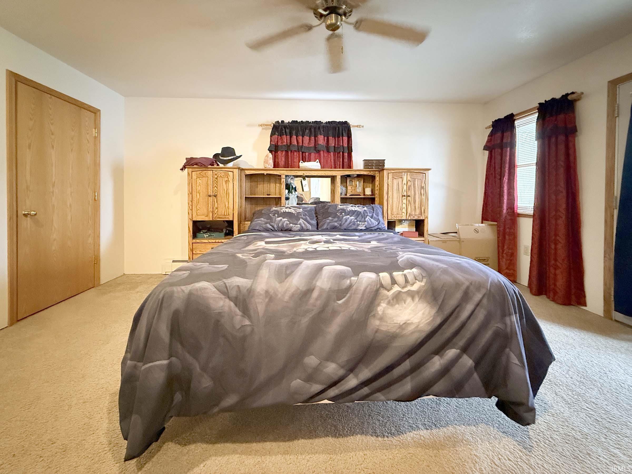 Bedroom with light colored carpet and ceiling fan