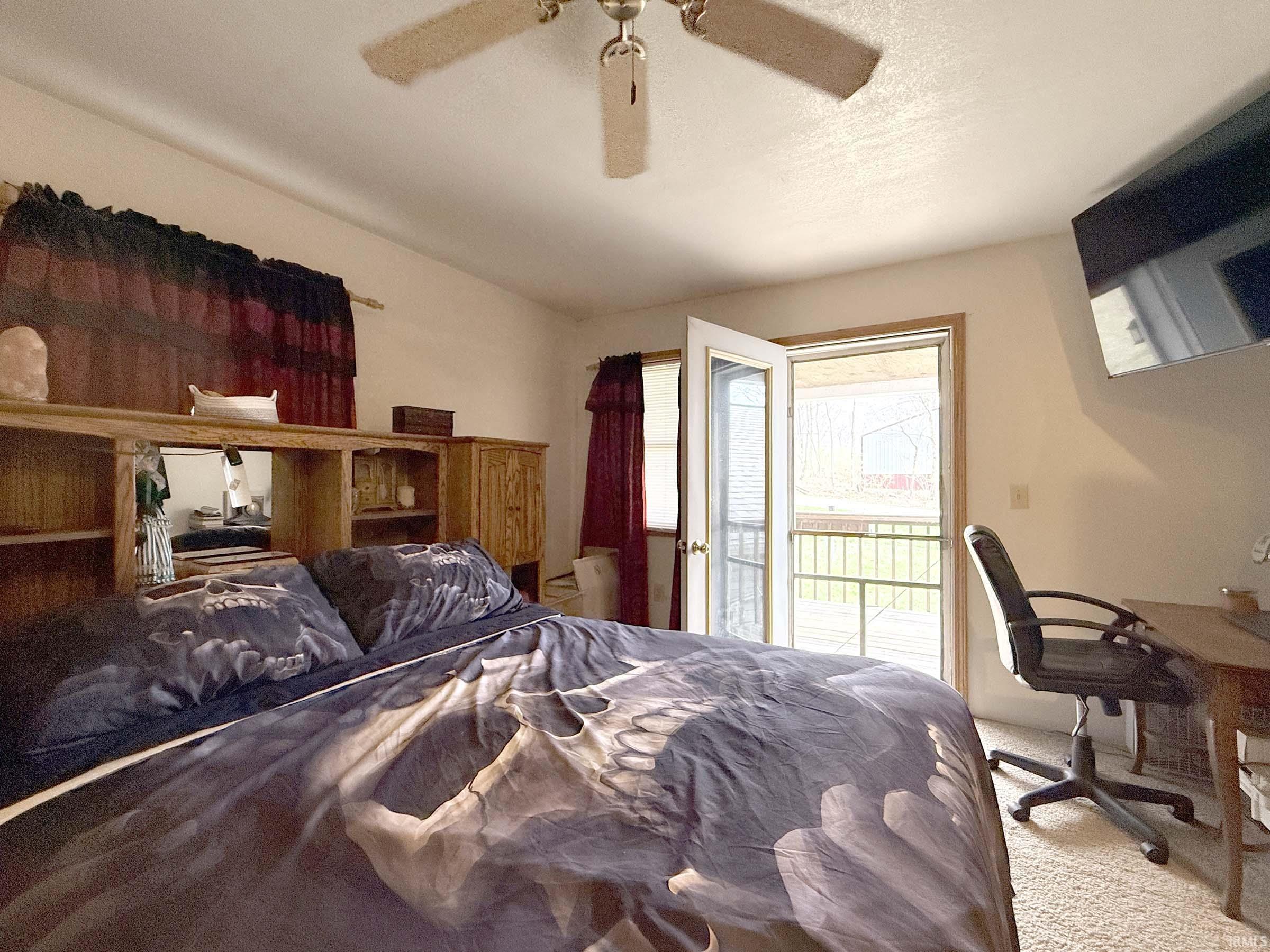 Bedroom featuring access to exterior, ceiling fan, and a desk