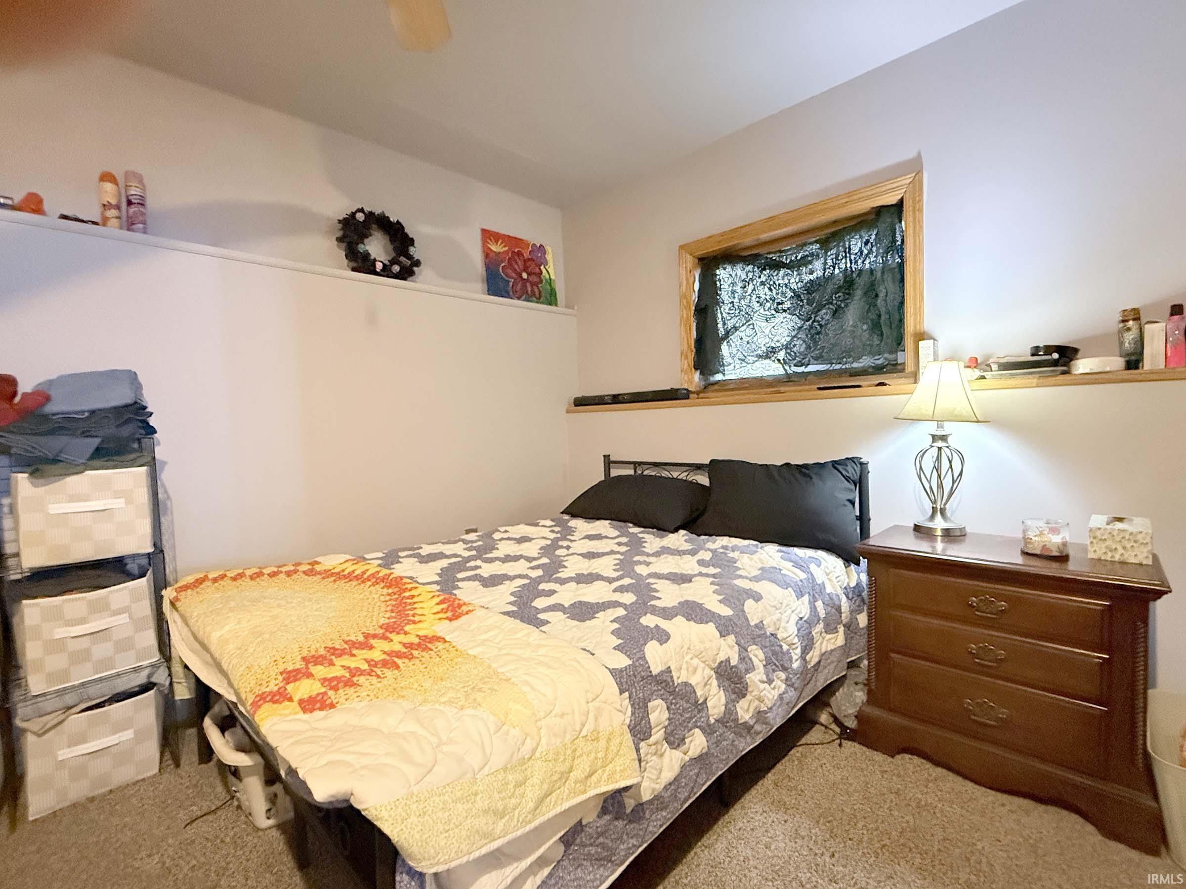 Carpeted bedroom with a ceiling fan