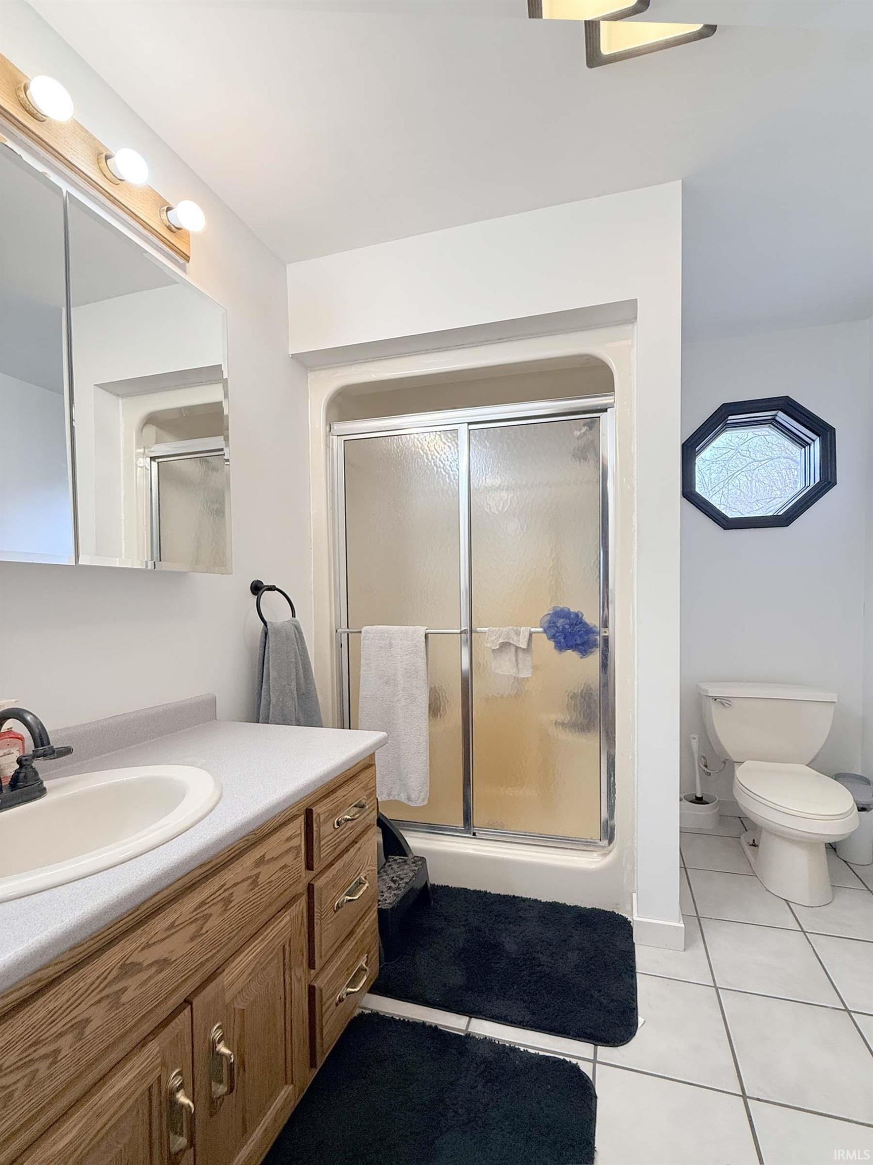 Full bathroom featuring vanity and light tile patterned flooring