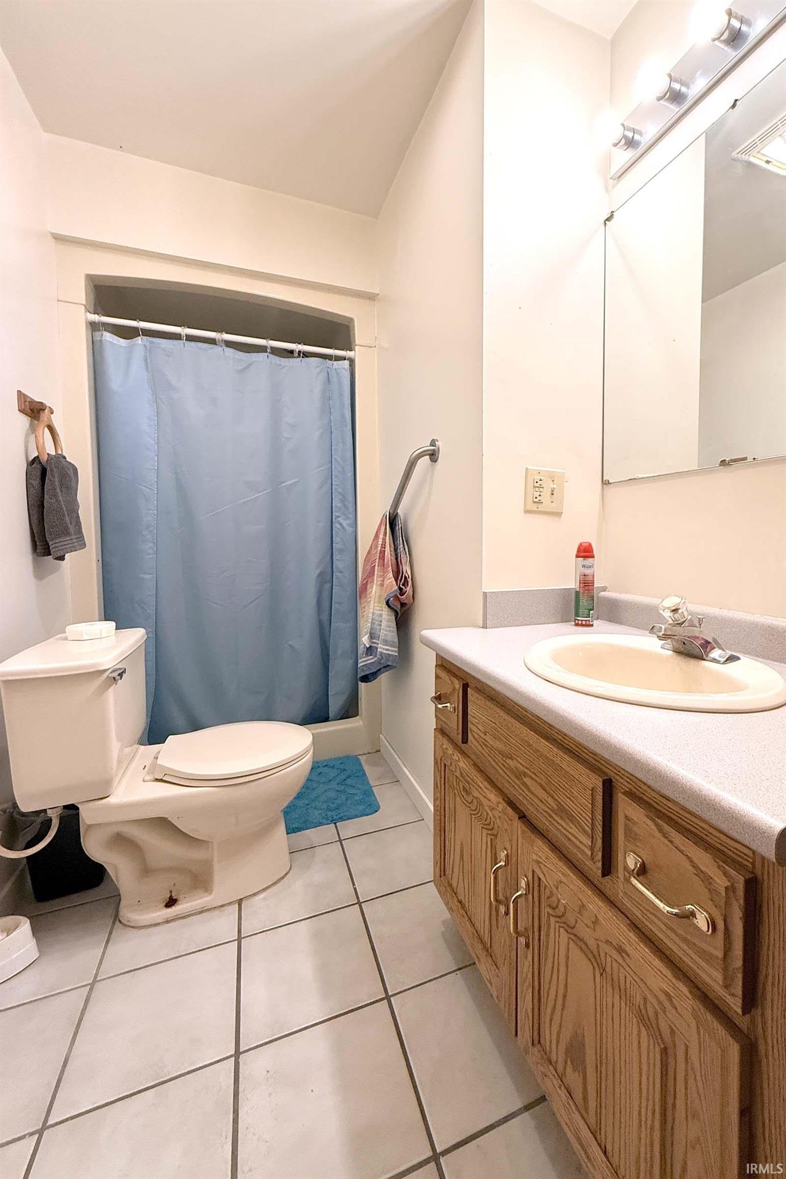 Full bathroom featuring vanity, a shower with shower curtain, and light tile patterned flooring
