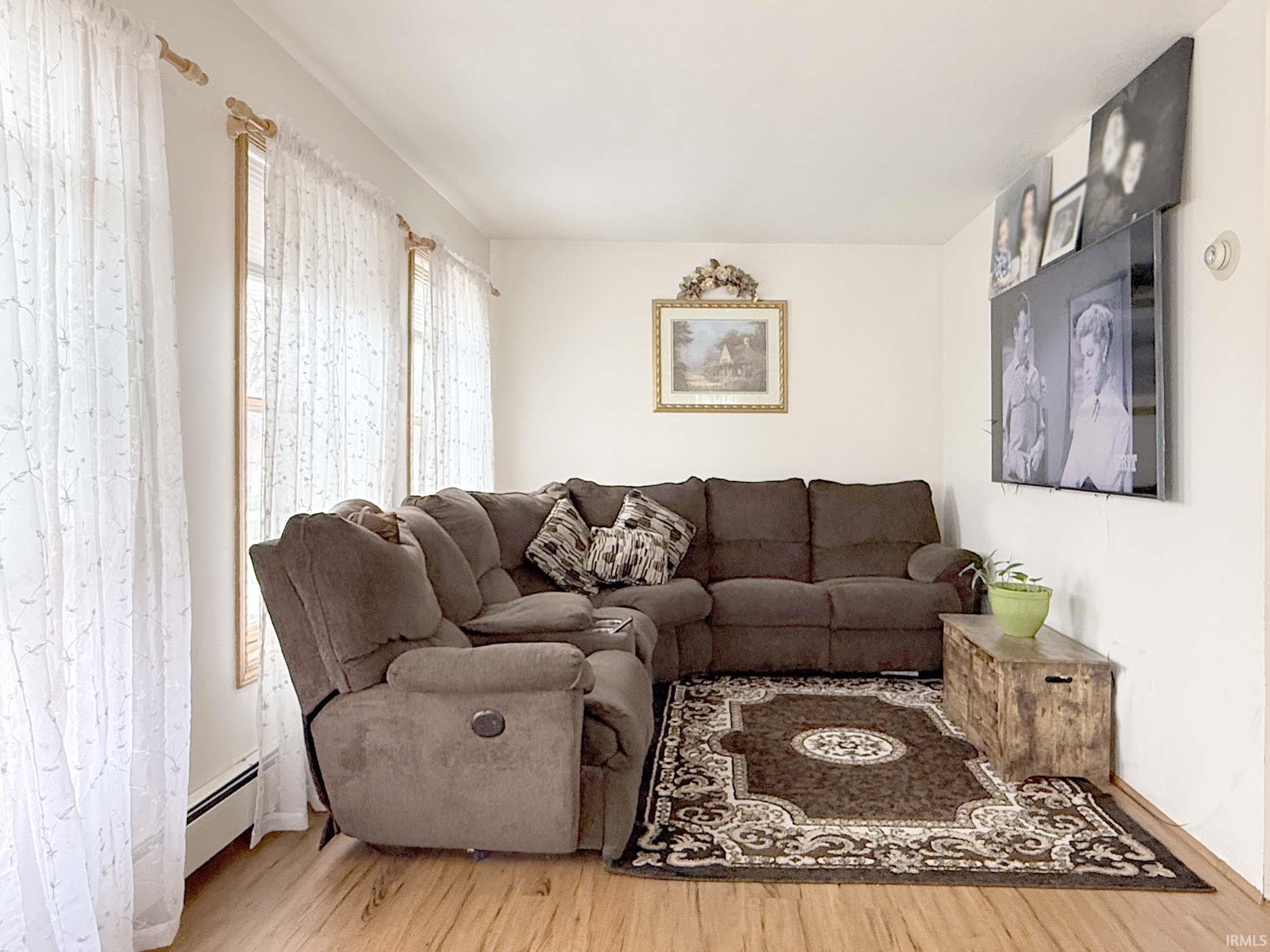 Living room featuring light wood-style floors and baseboard heating