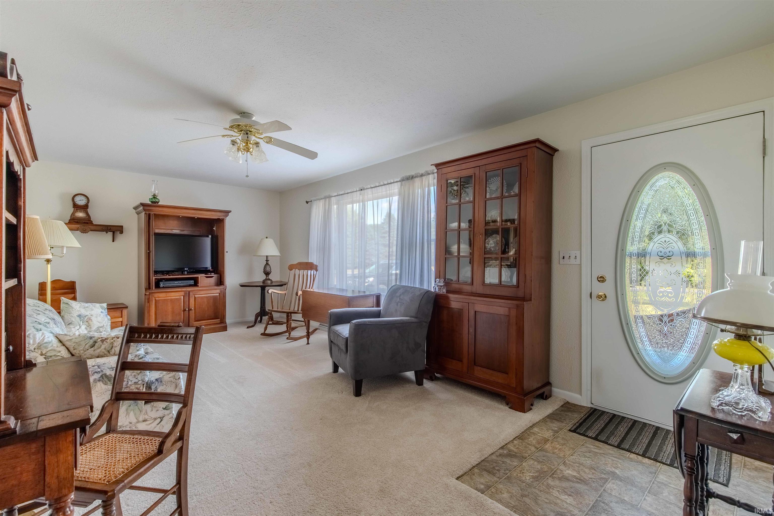 Entryway with ceiling fan and light colored carpet