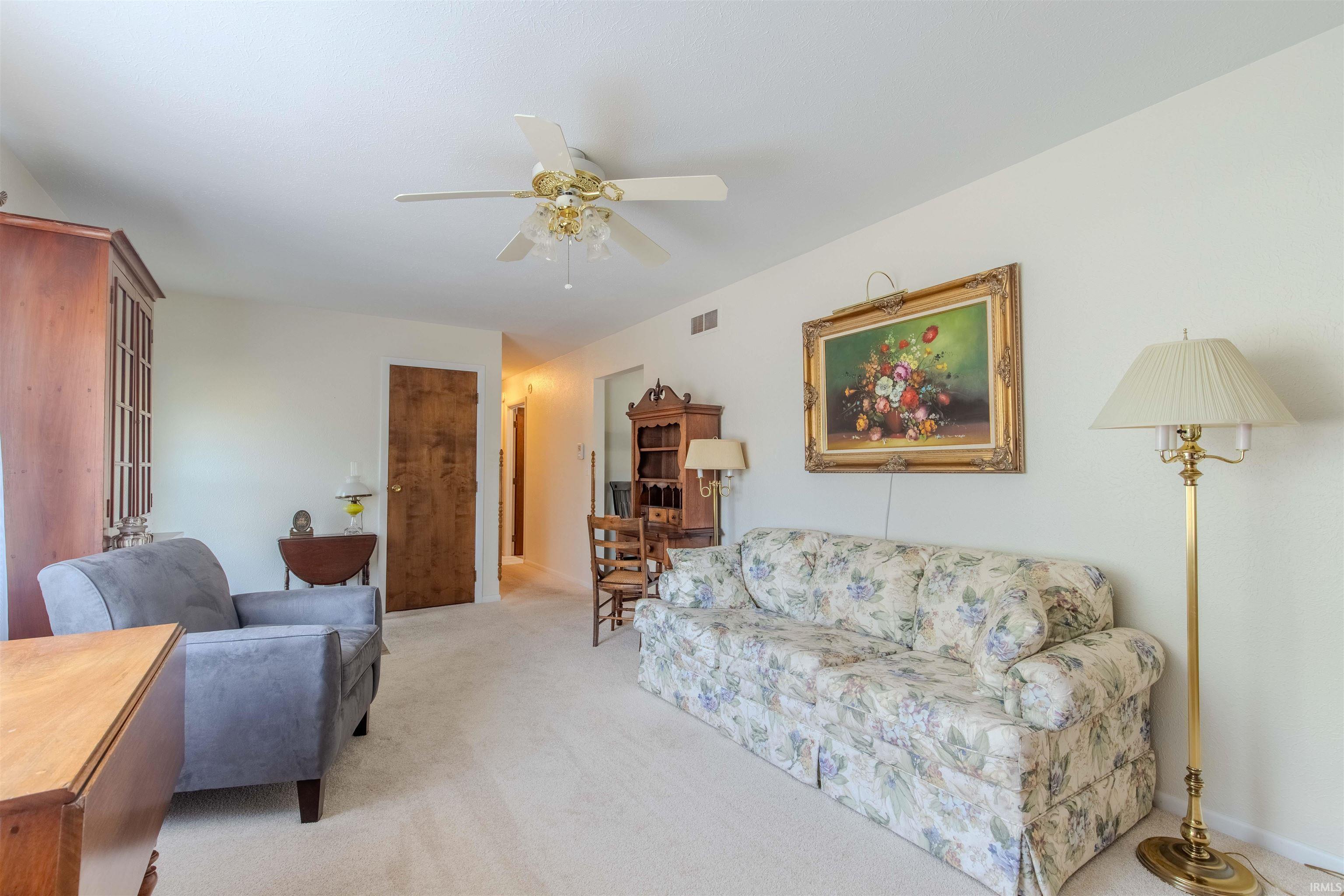 Living room with light carpet and a ceiling fan