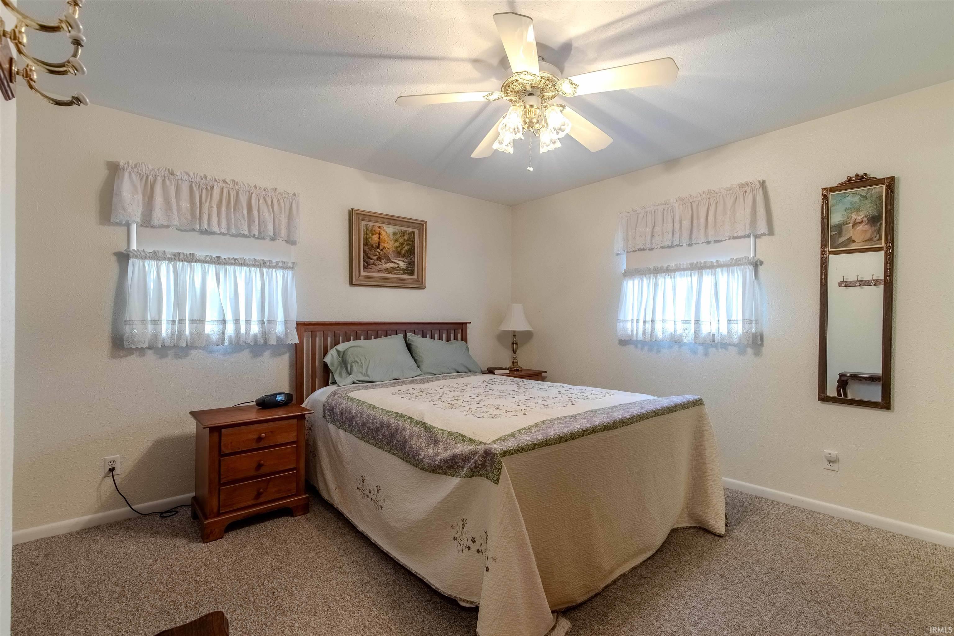 Carpeted bedroom with baseboards and a ceiling fan